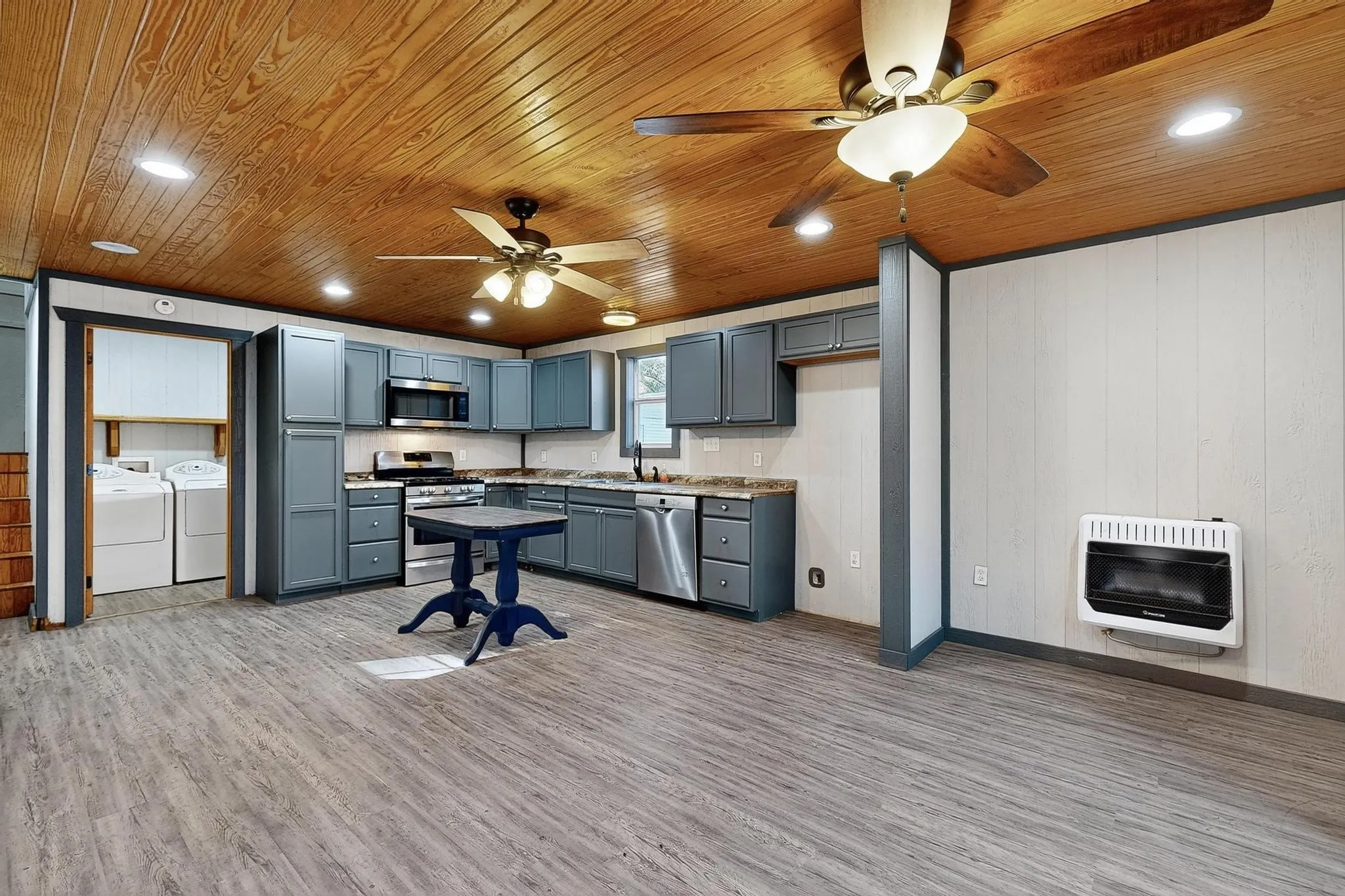 Kitchen featuring recessed lighting, light wood-style floors, stainless steel appliances, washing machine and dryer, and gray cabinetry