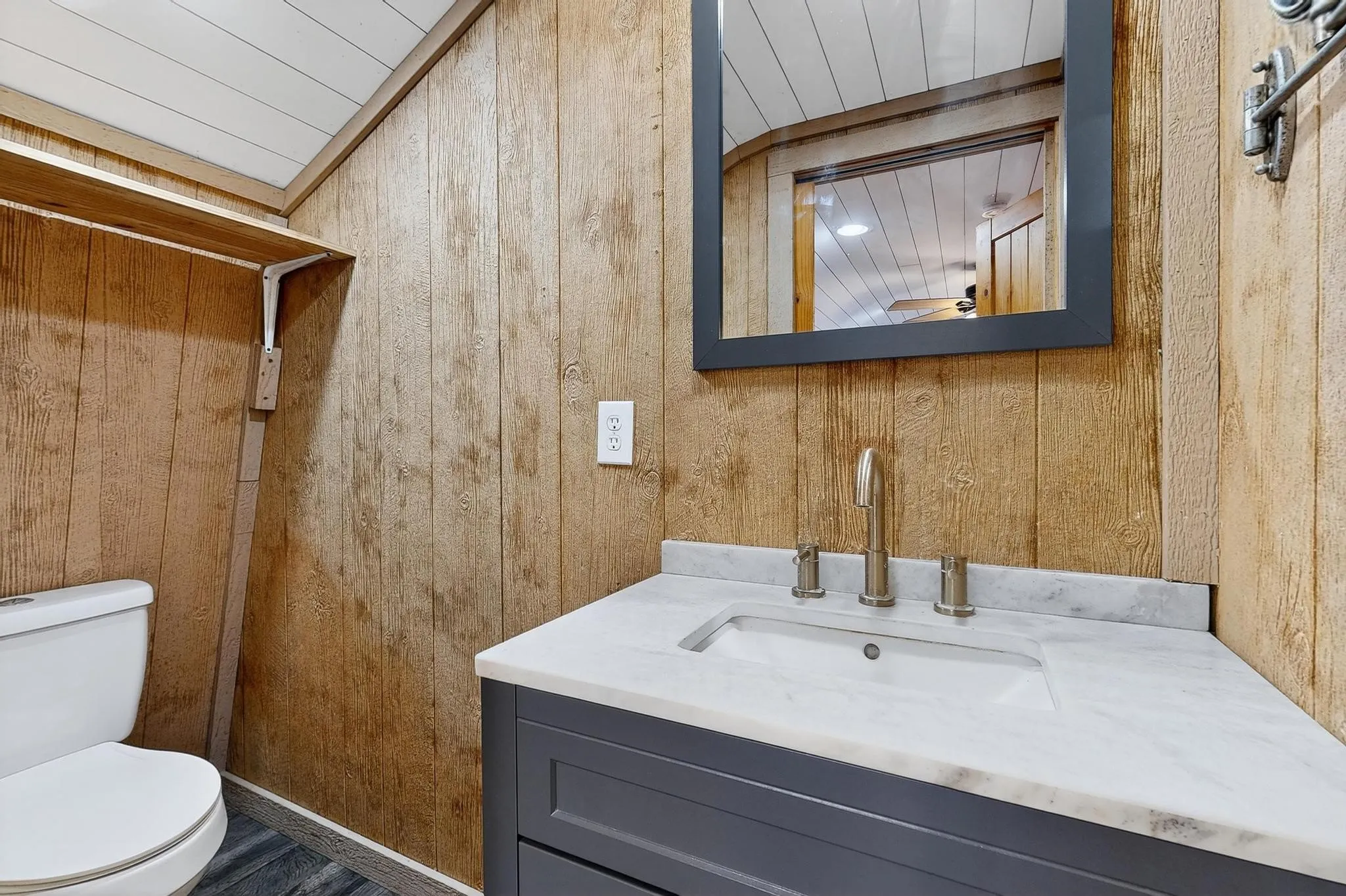 Bathroom featuring vanity and wood walls
