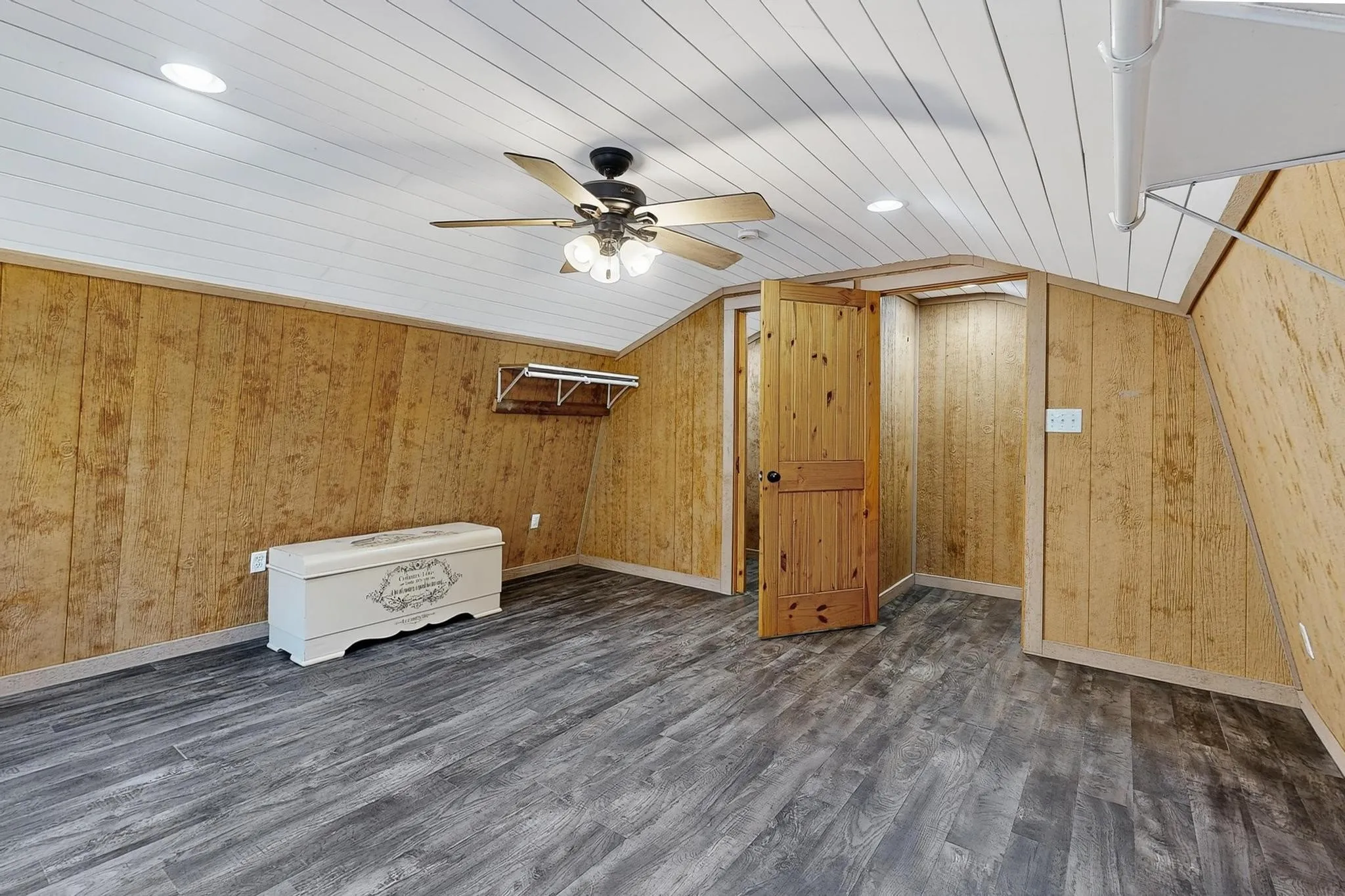 Bedroom featuring dark wood finished floors, vaulted ceiling, a ceiling fan, wood ceiling, and wooden walls