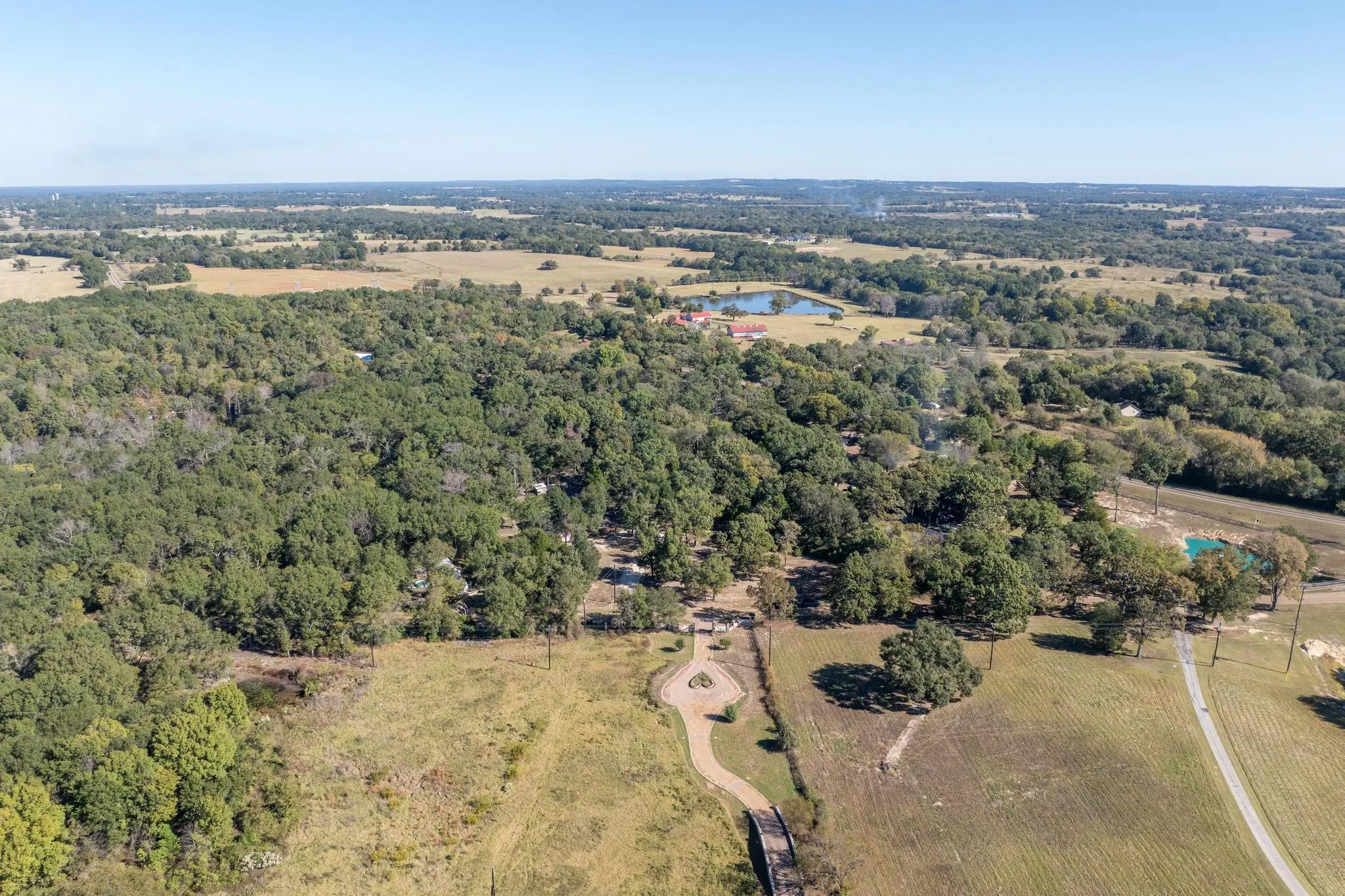 Aerial view of property's location with a heavily wooded area and a large body of water