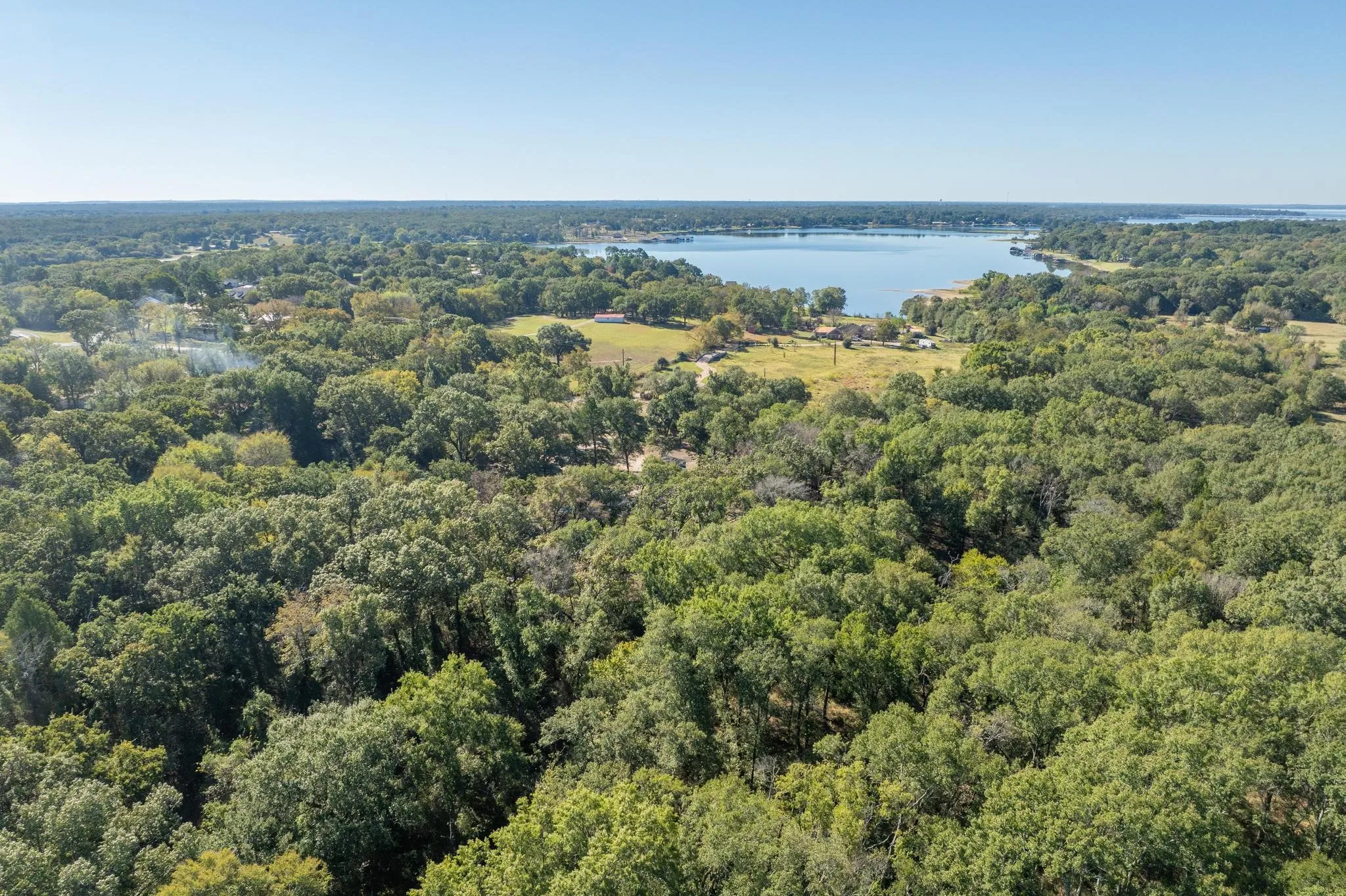 Bird's eye view of a heavily wooded area and a nearby body of water
