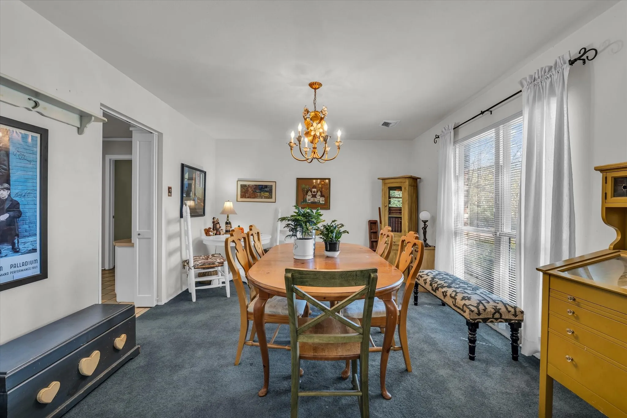 Dining space with dark carpet and a chandelier