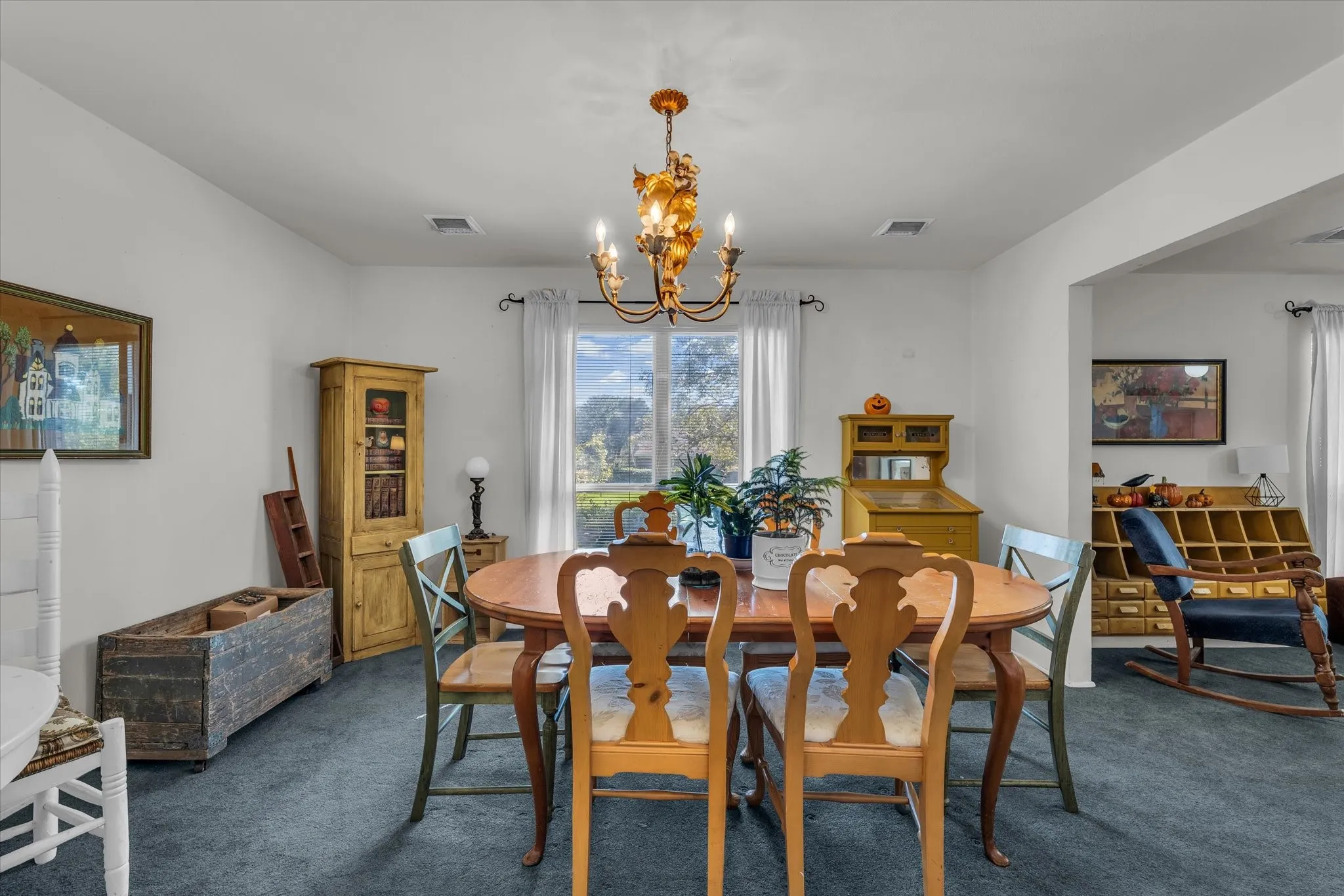 Dining room with dark colored carpet and a chandelier