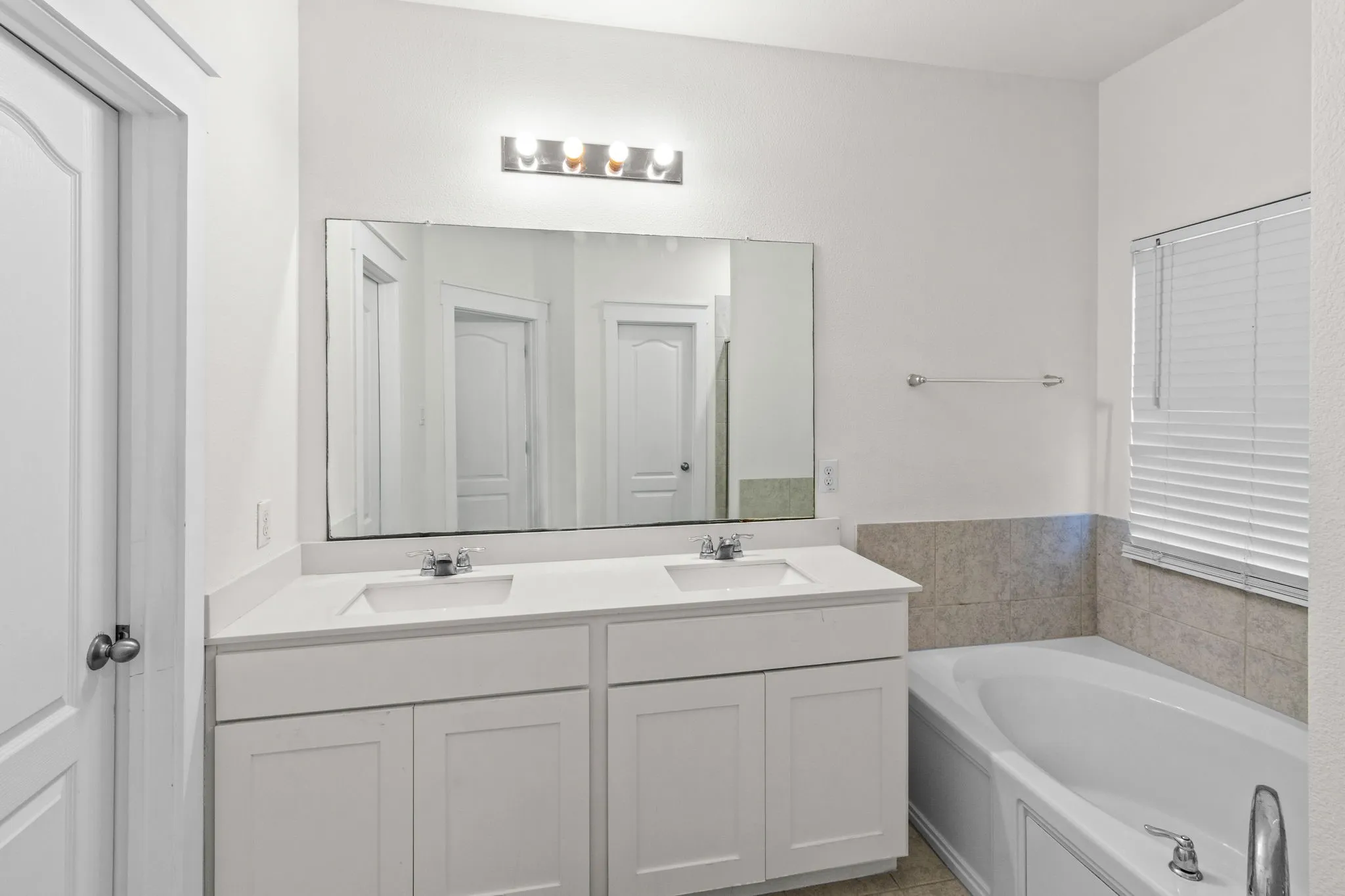 Bathroom with double vanity and a garden tub