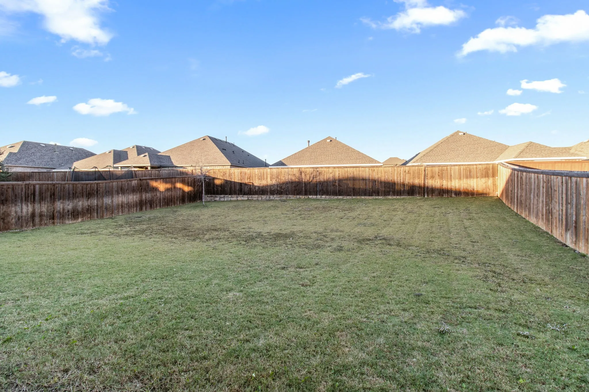 Fenced backyard featuring a residential view