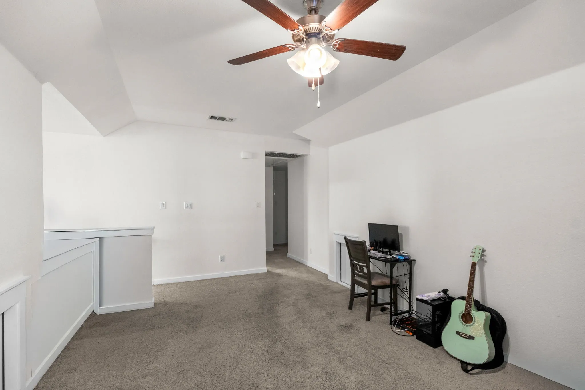 Home office featuring carpet flooring and vaulted ceiling