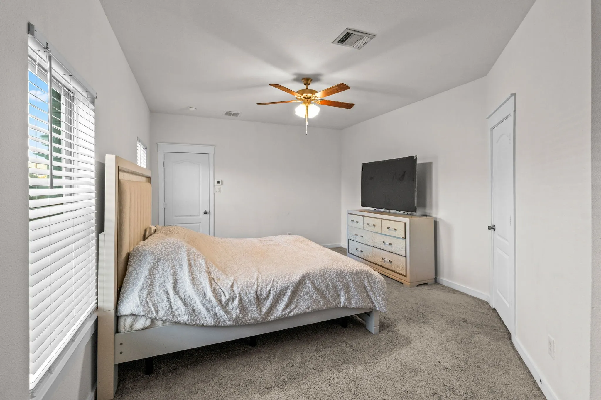 Carpeted bedroom featuring baseboards and a ceiling fan