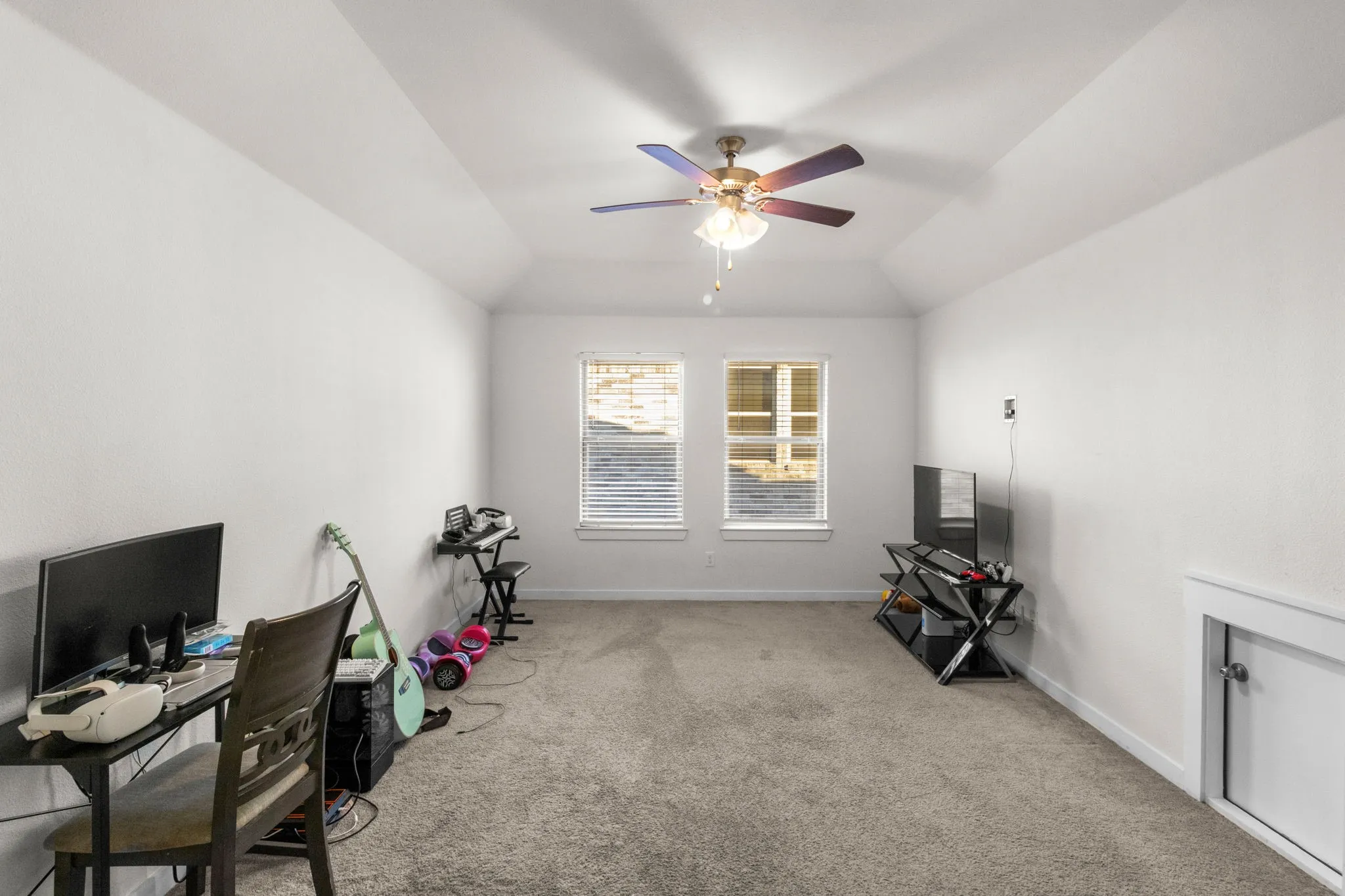 Office area with light carpet, lofted ceiling, and a ceiling fan
