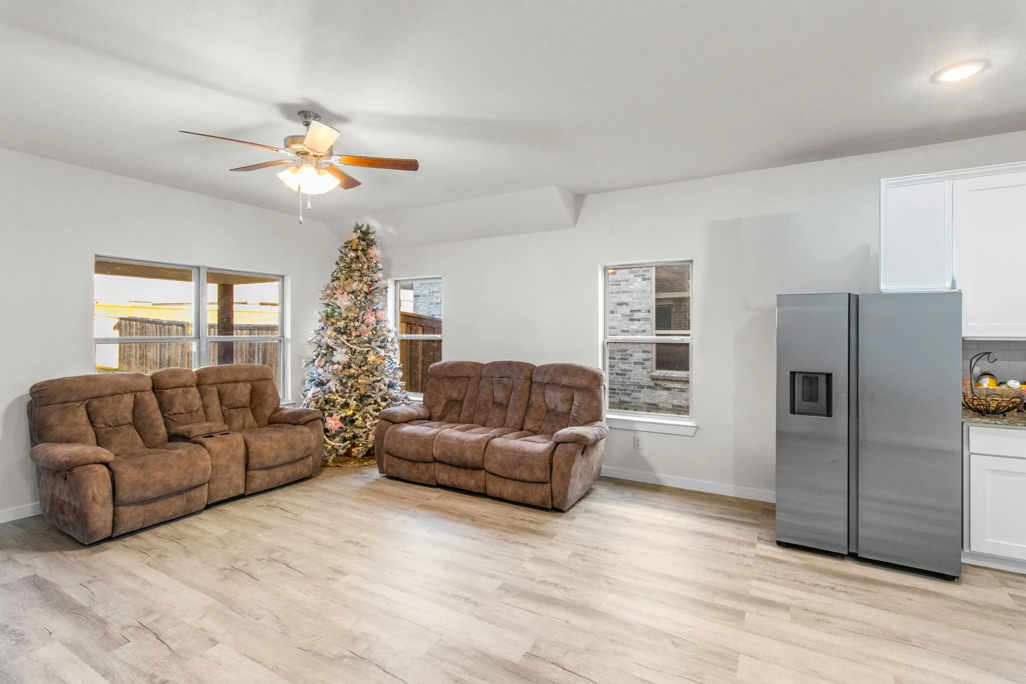 Living room with light wood-style floors and a ceiling fan