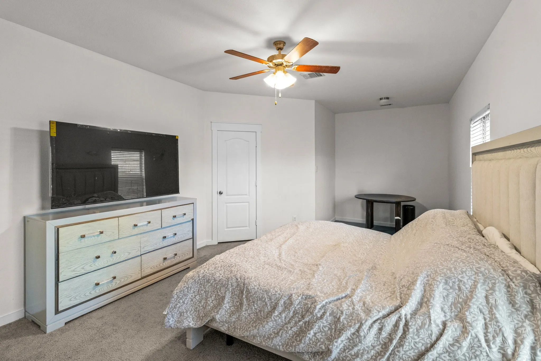Bedroom with light colored carpet and ceiling fan