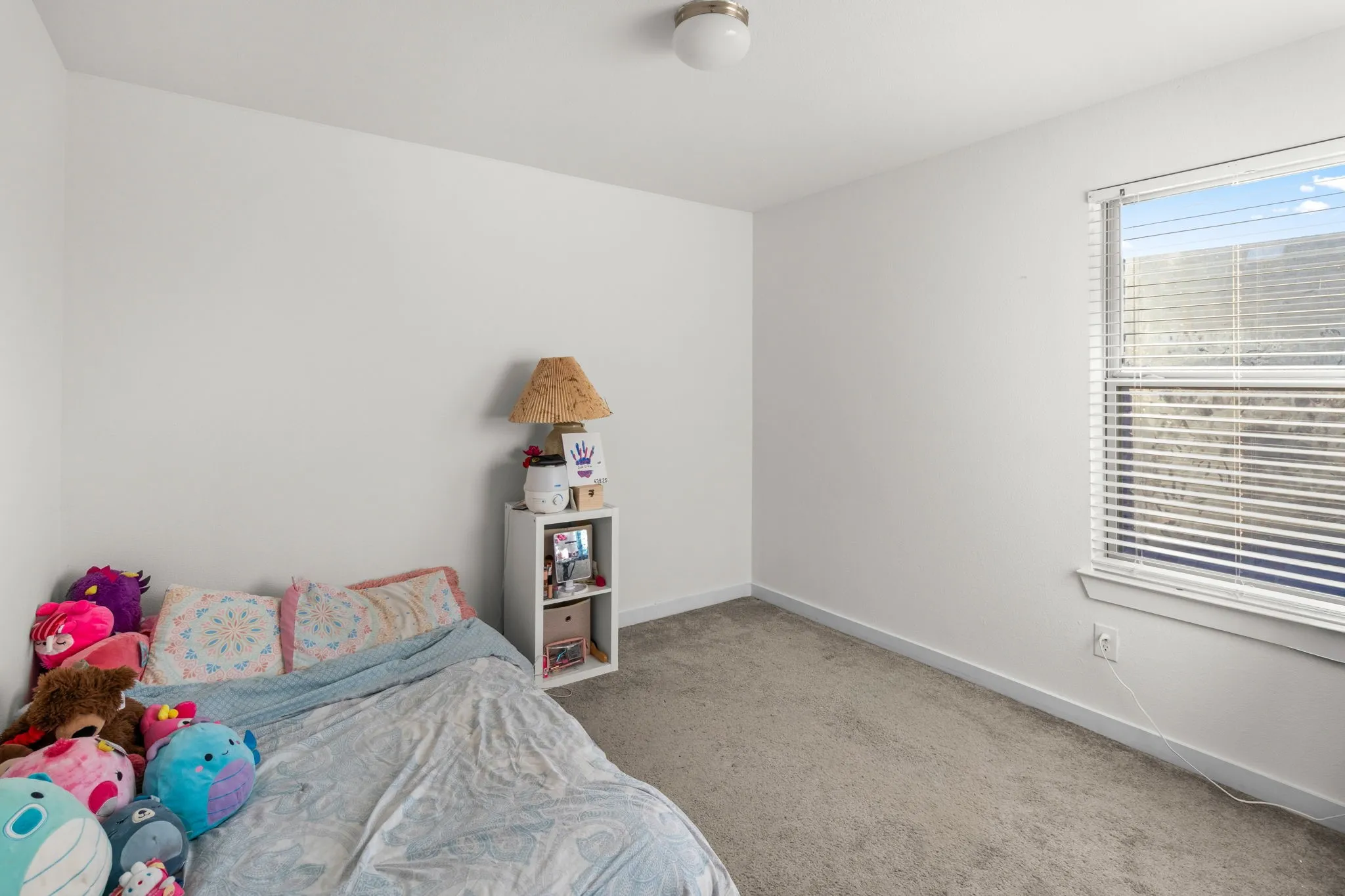 Bedroom with baseboards and light colored carpet