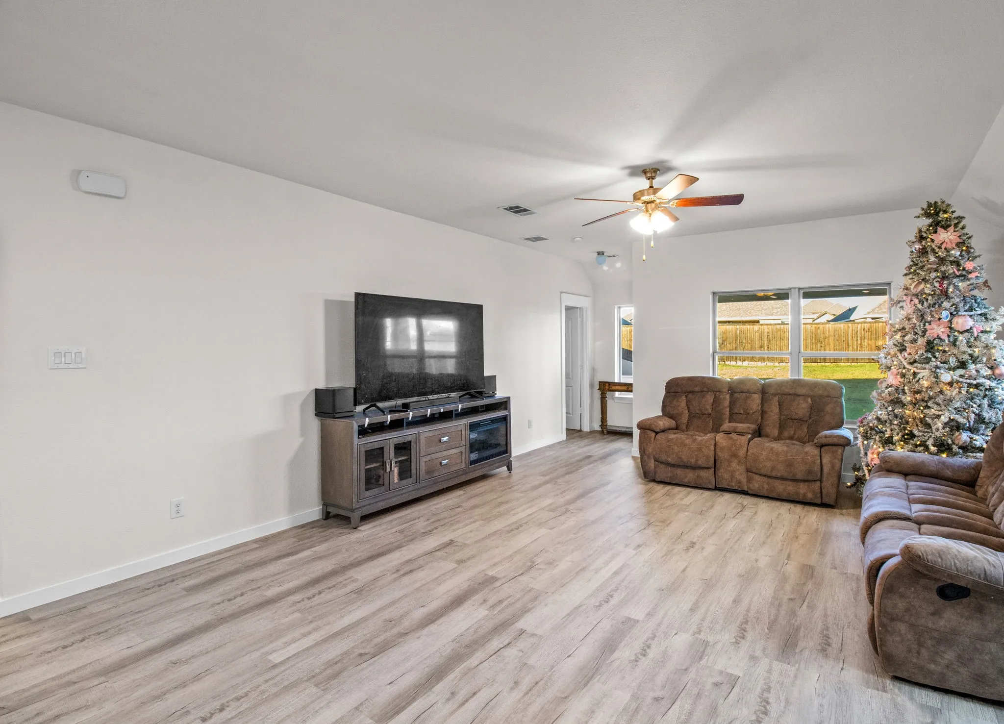Living room with light wood-type flooring and a ceiling fan
