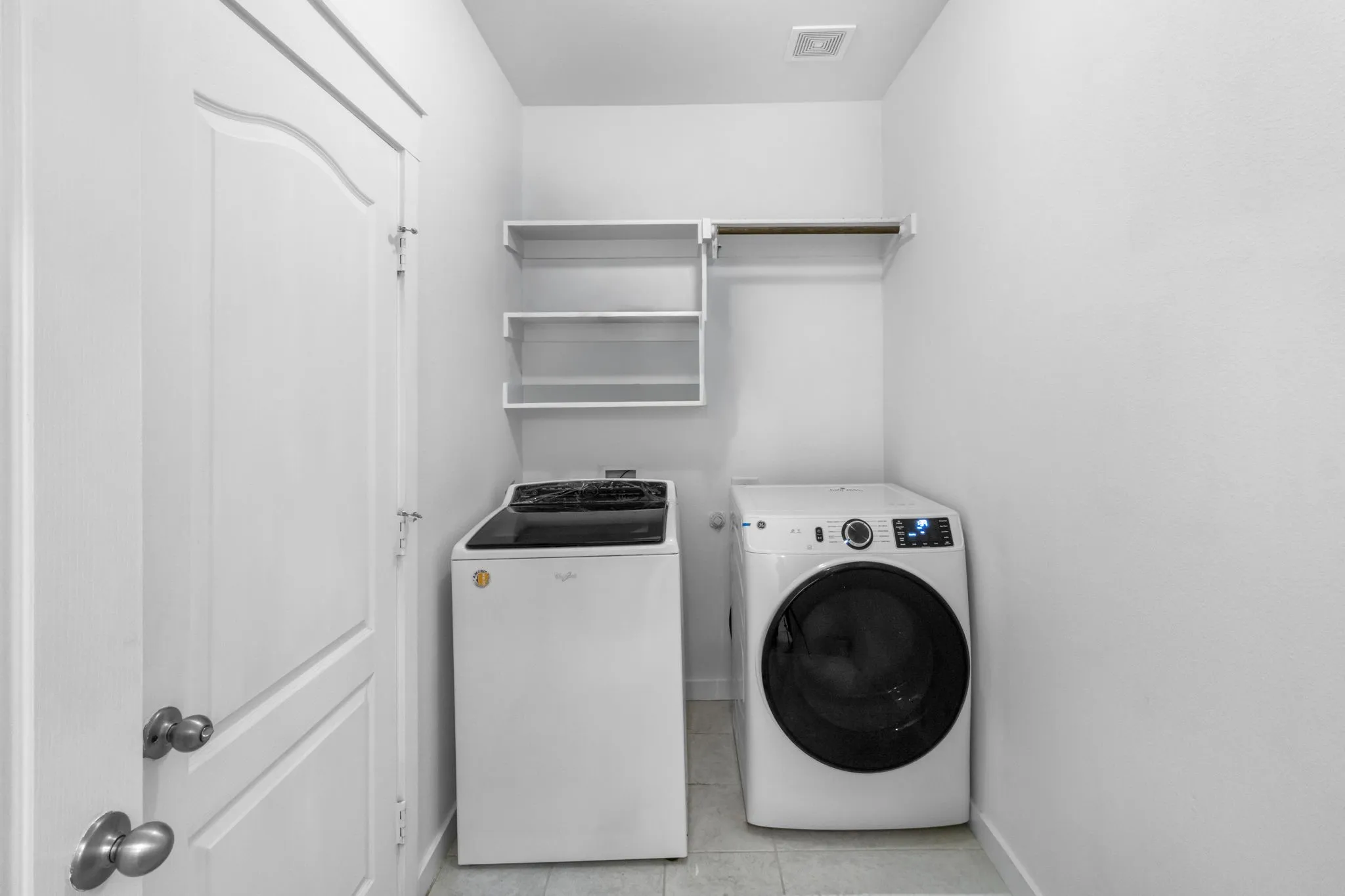Laundry room featuring light tile patterned floors and washer and clothes dryer