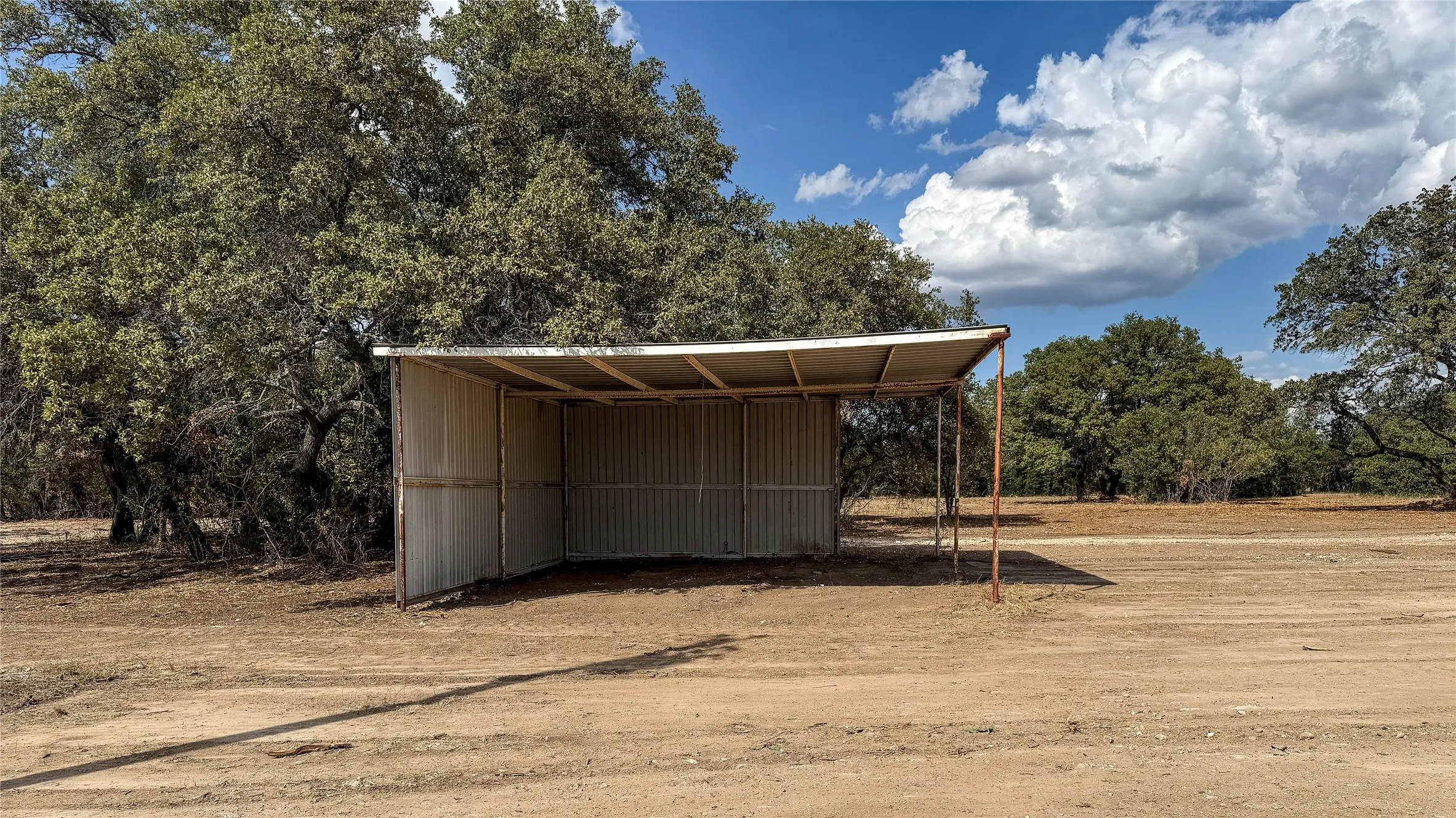 View of outdoor structure with a carport and driveway
