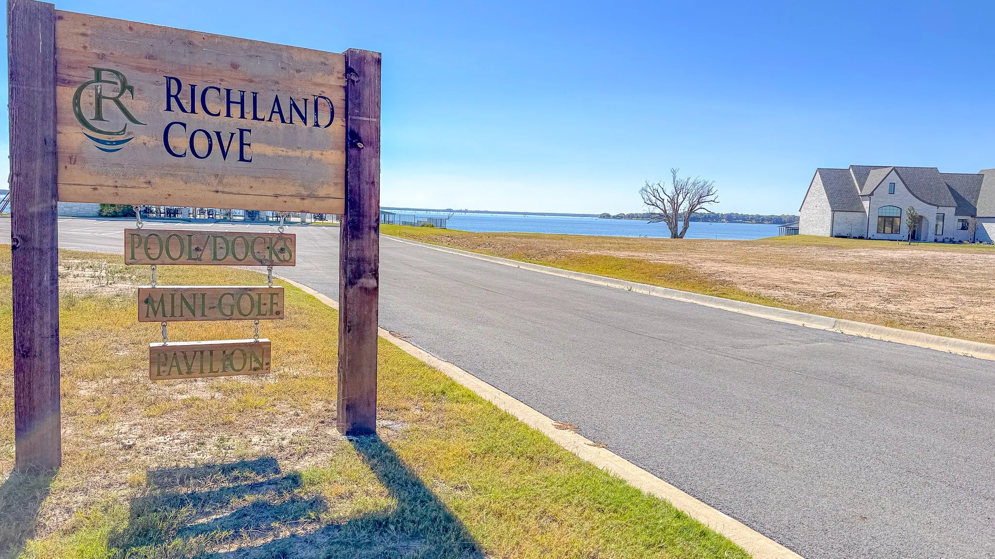 View of asphalt road with a water view and curbs