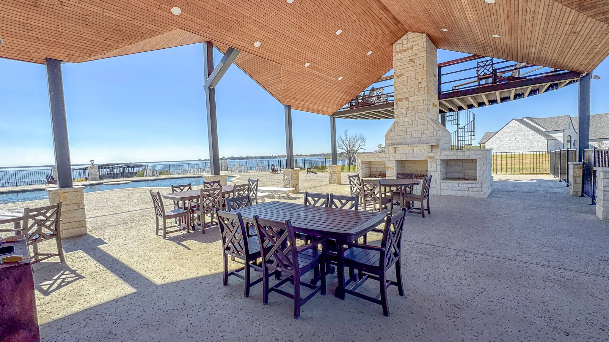 View of patio featuring an outdoor stone fireplace, outdoor dining area, and a water view
