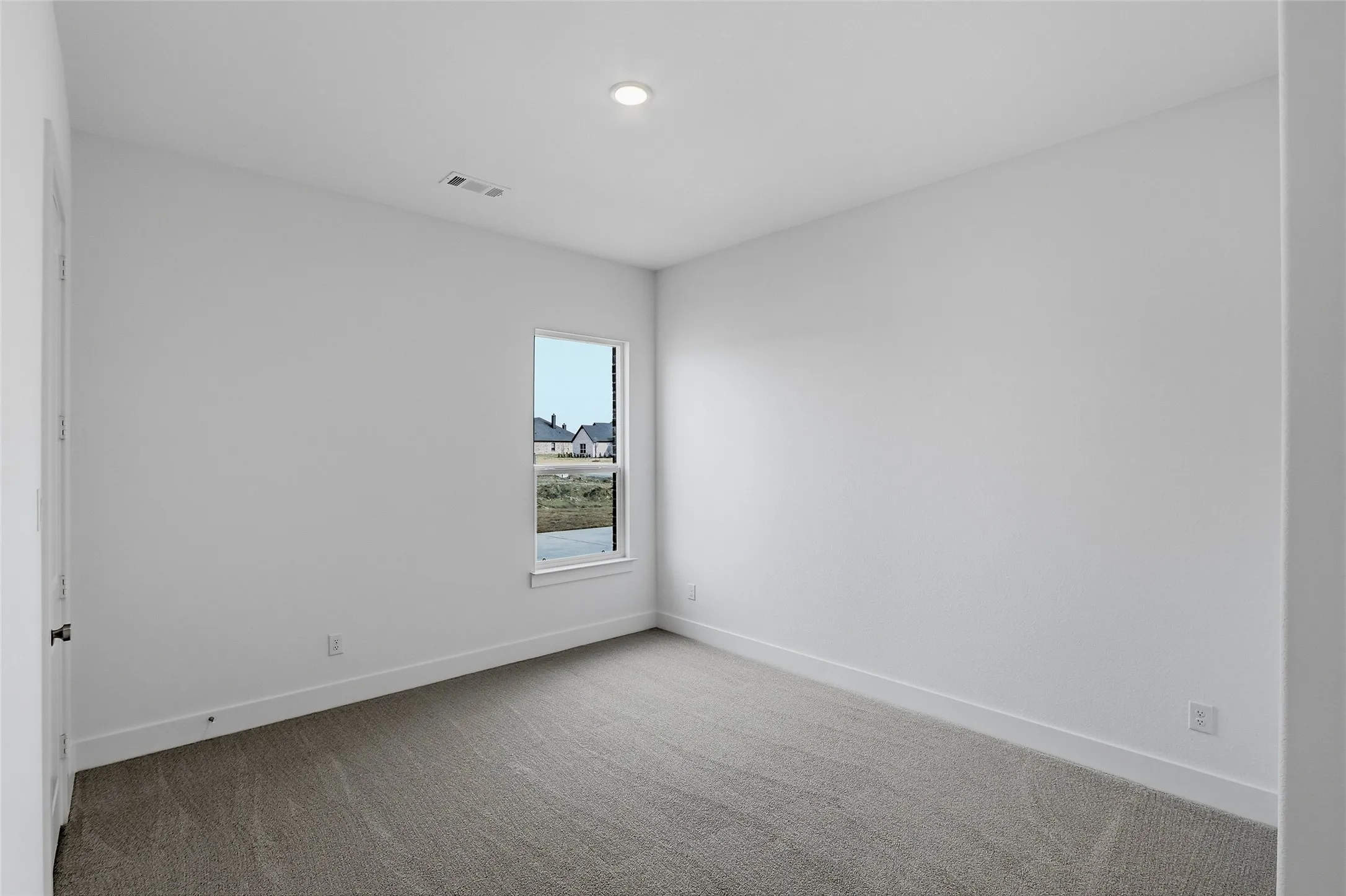 Empty room with baseboards and light colored carpet