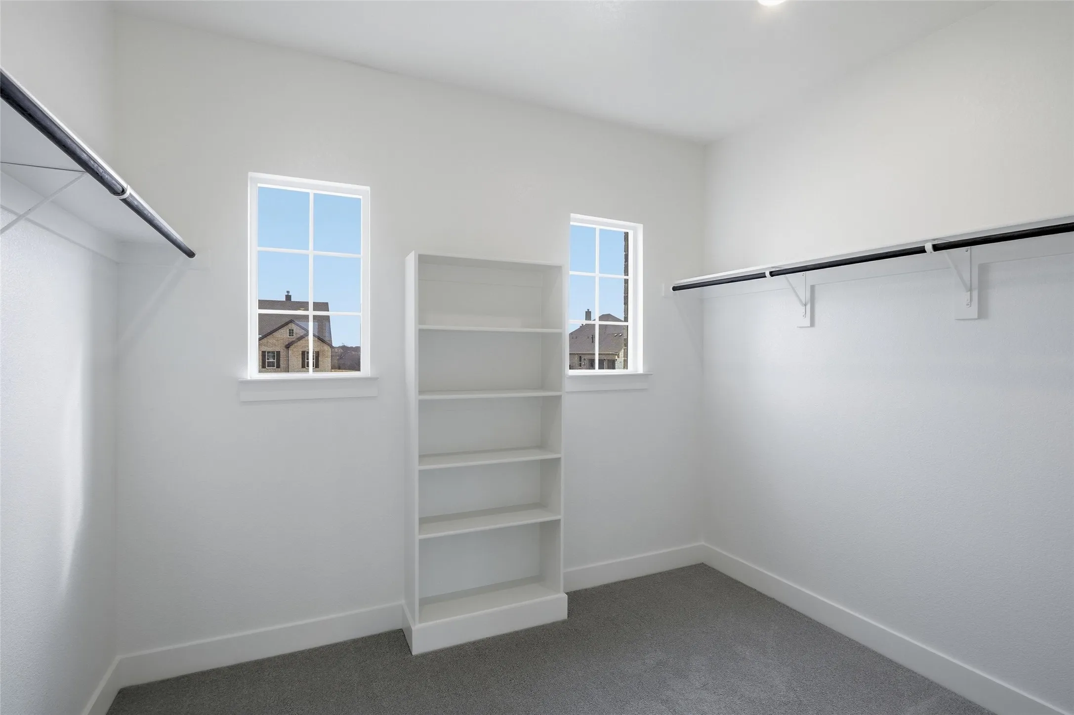 Walk in closet featuring dark carpet