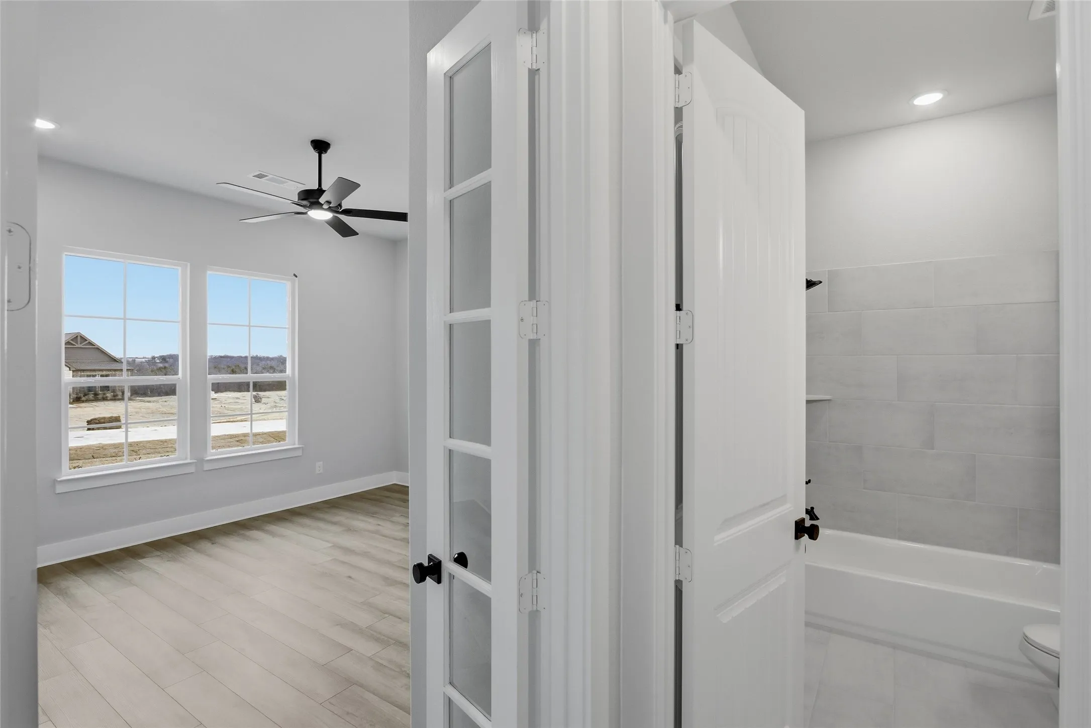 Full bath featuring recessed lighting, ceiling fan, washtub / shower combination, and light wood-type flooring