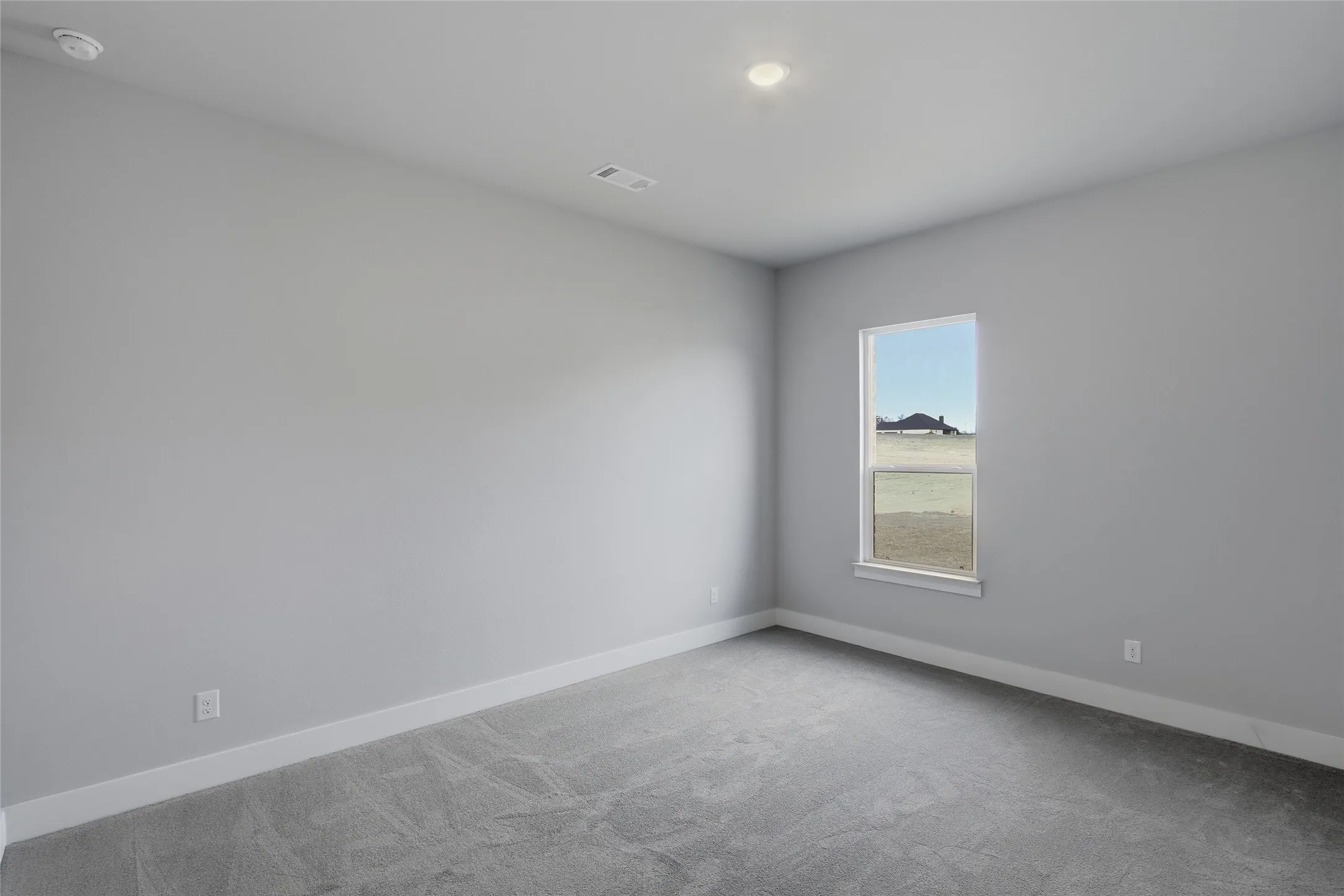 Carpeted empty room with baseboards