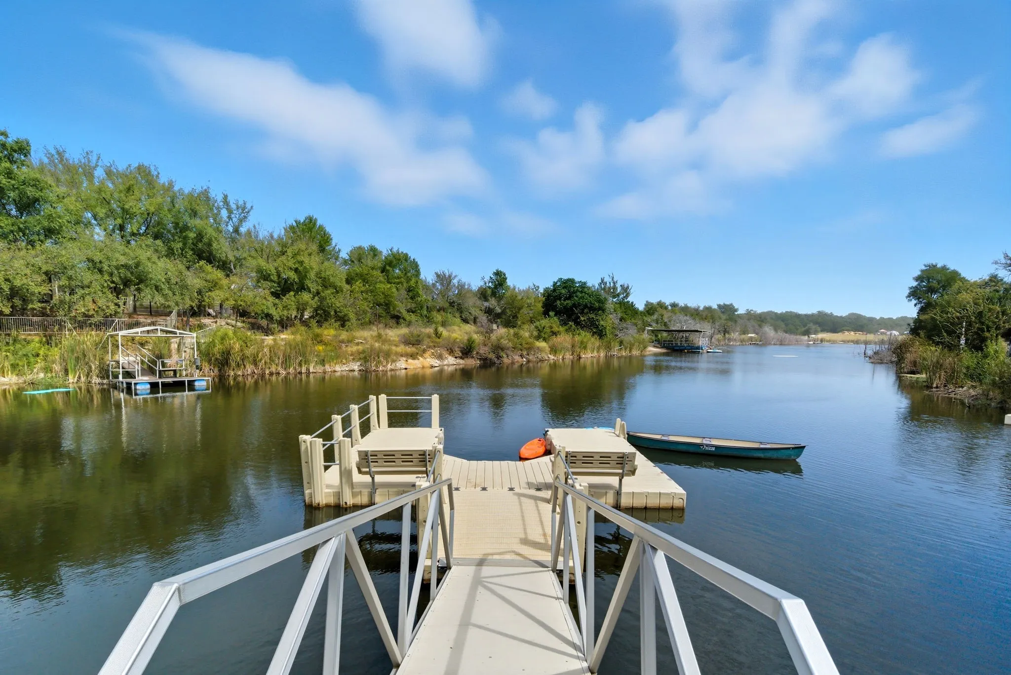 Dock area with a water view and view of wooded area