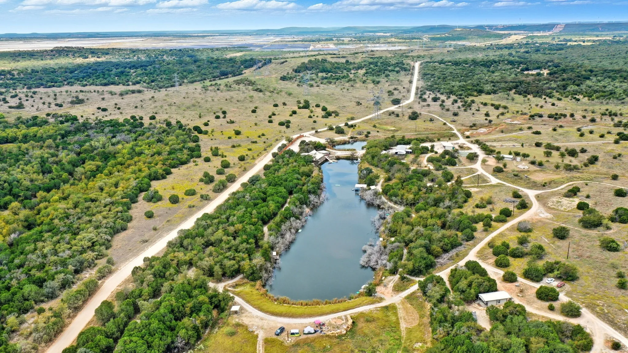 Aerial view of property and surrounding area featuring a large body of water and rural landscape