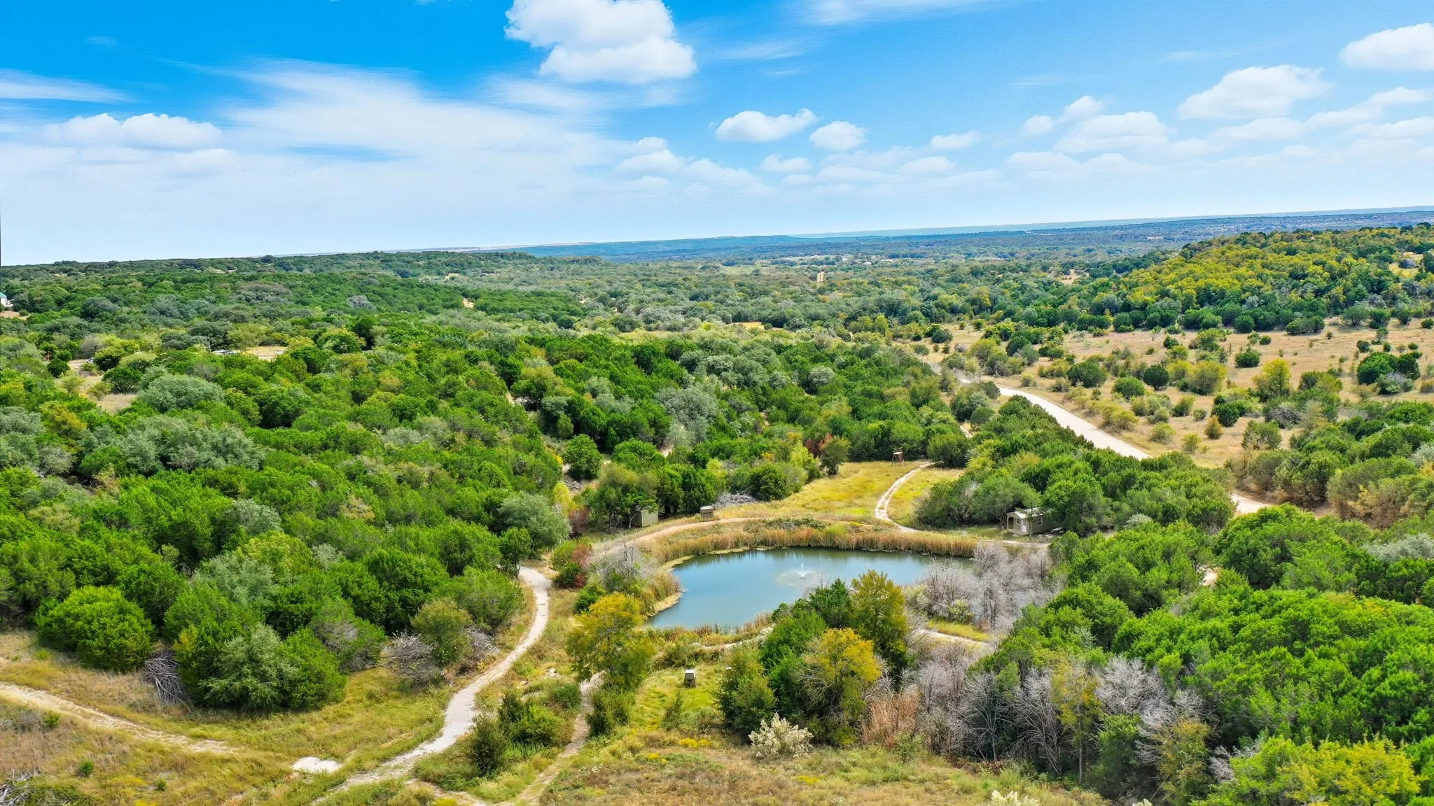 Bird's eye view of a nearby body of water and a heavily wooded area