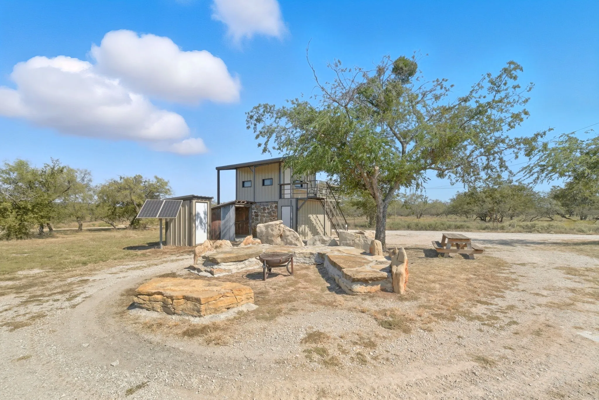 View of front of house featuring solar panels and an outbuilding