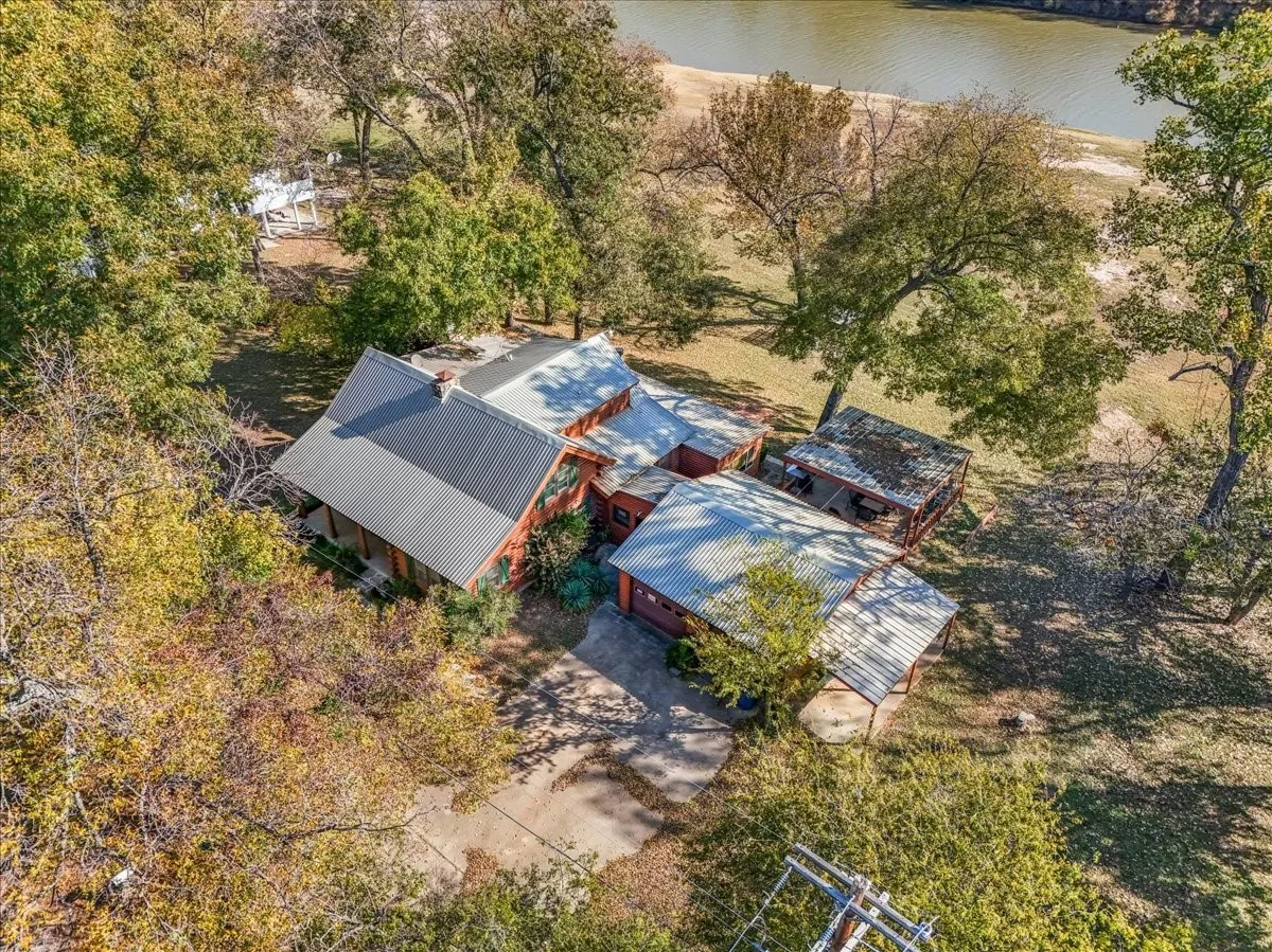 Aerial view of property and surrounding area featuring a nearby body of water