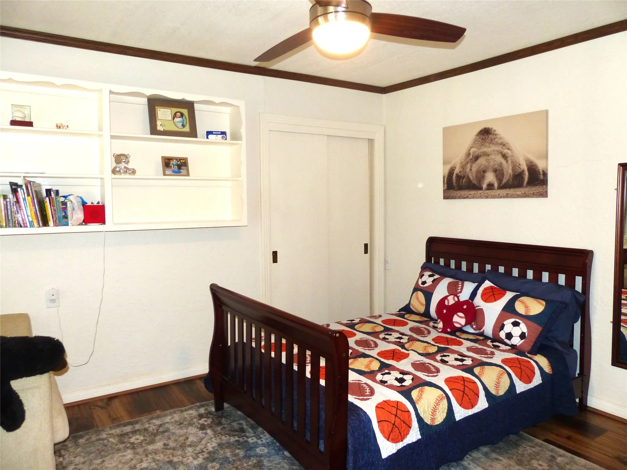 Bedroom with crown molding, dark wood-type flooring, and a ceiling​​‌​​​​‌​​‌‌​‌‌​​​‌‌​‌​‌​‌​​​‌​​ fan