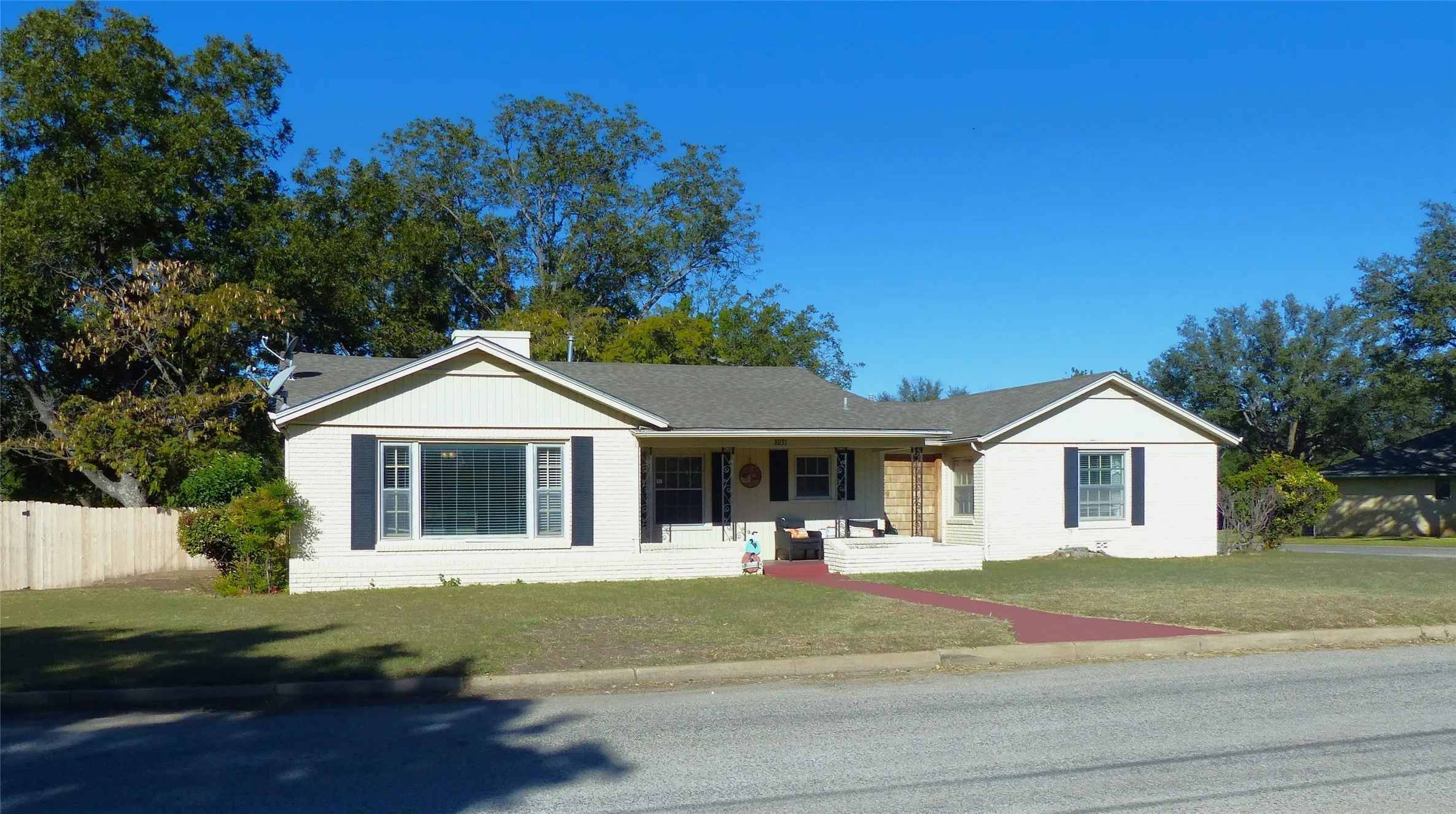 Single story home with covered porch and a shingled roof