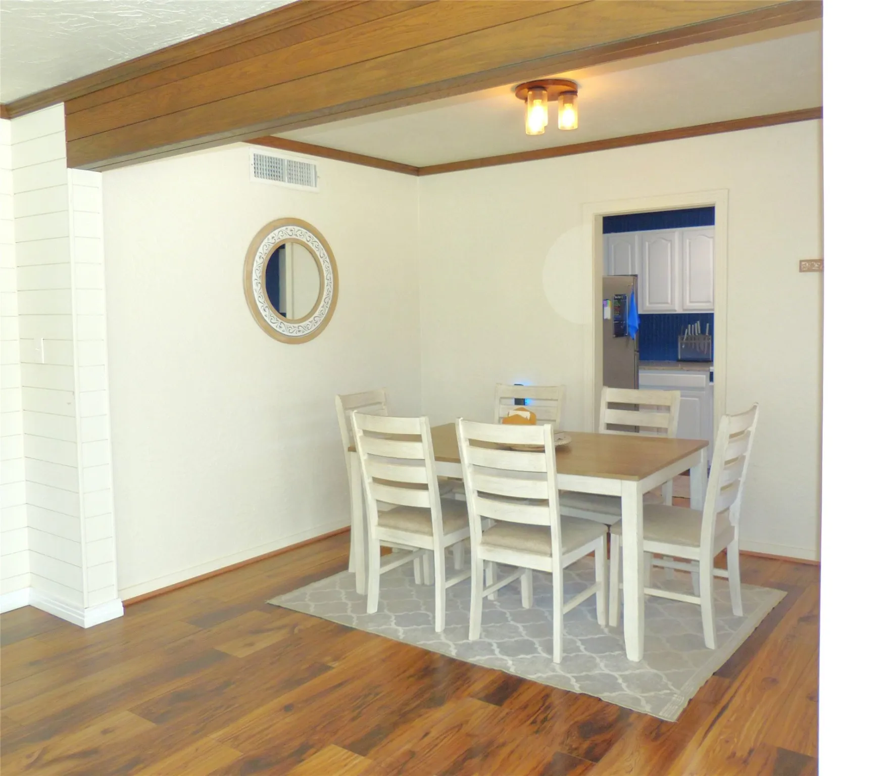 Dining space with ornamental molding and dark wood finished floors