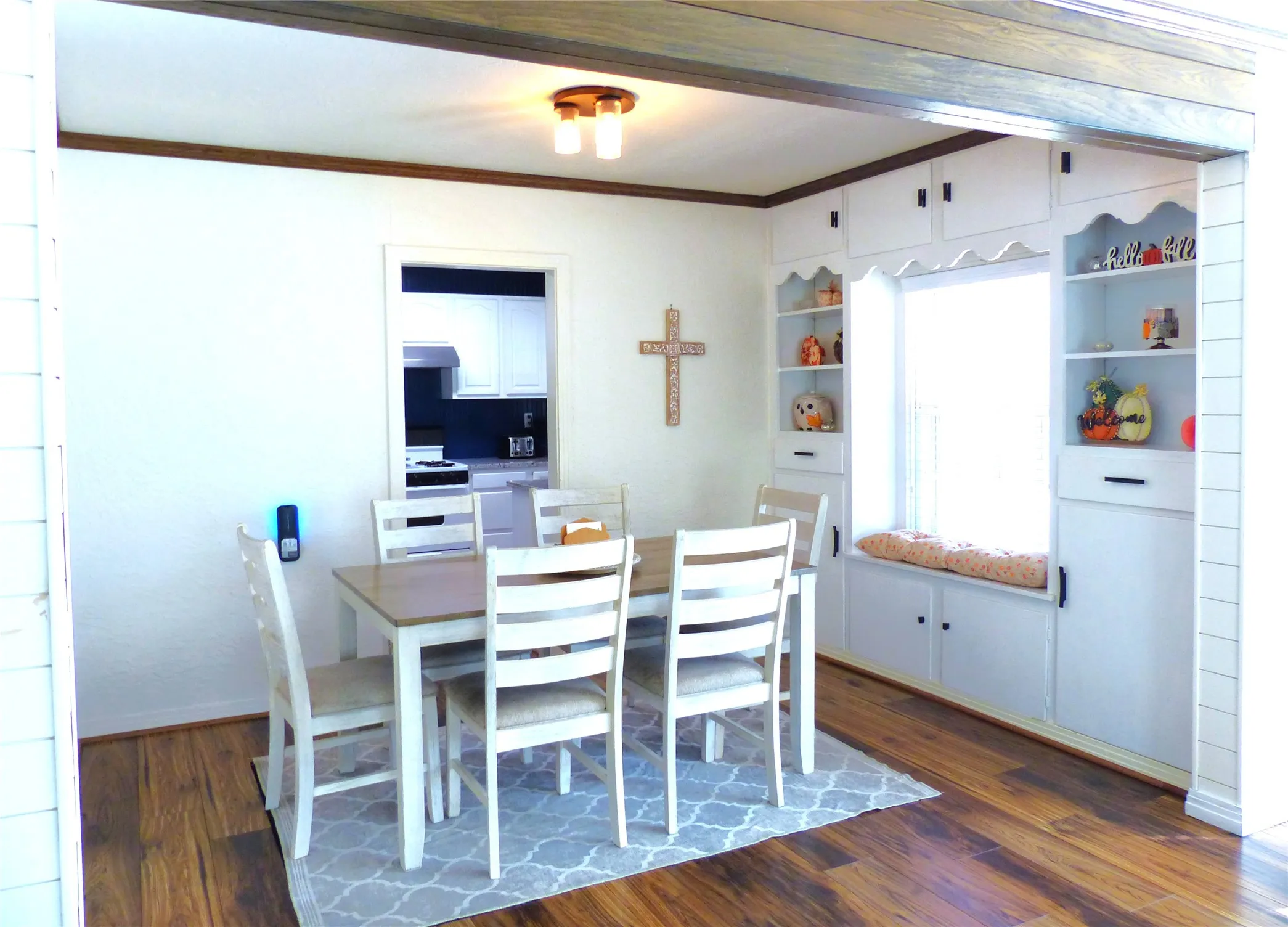 Dining space with dark wood-type flooring and crown molding