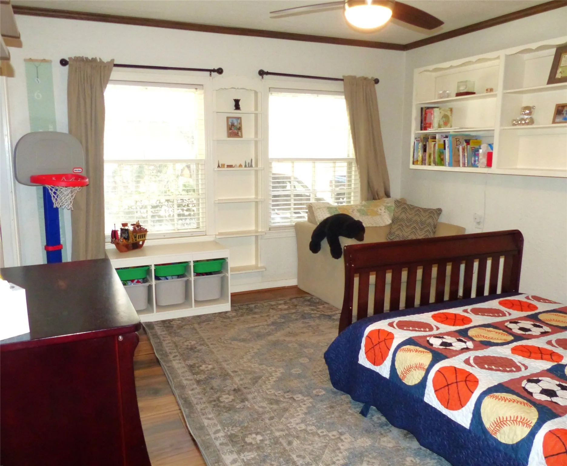 Bedroom with dark wood-style flooring, ornamental molding, and ceiling fan