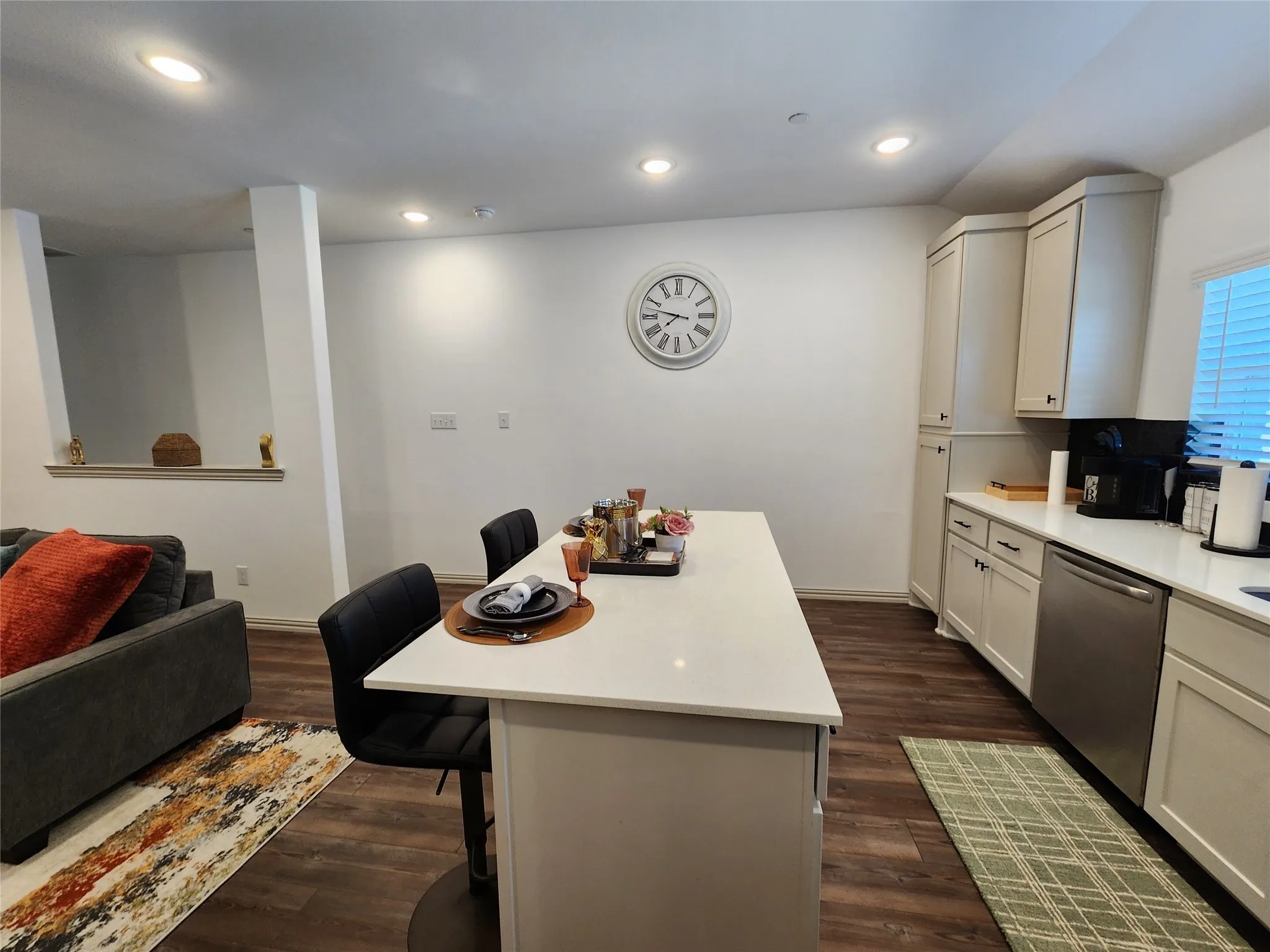 Kitchen featuring a breakfast bar area, stainless steel dishwasher, open floor plan, dark wood finished floors, and recessed lighting