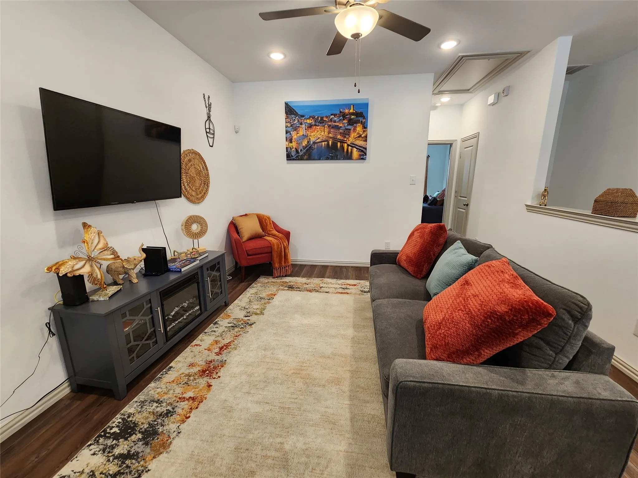 Living area featuring wood finished floors, attic access, ceiling fan, and recessed lighting