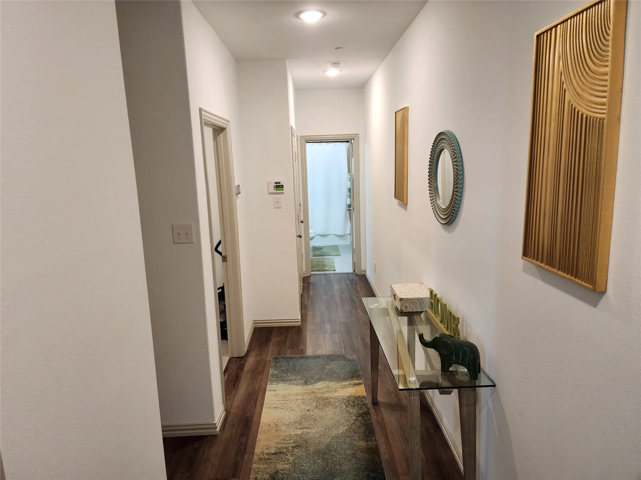 Corridor with dark wood-style floors and baseboards