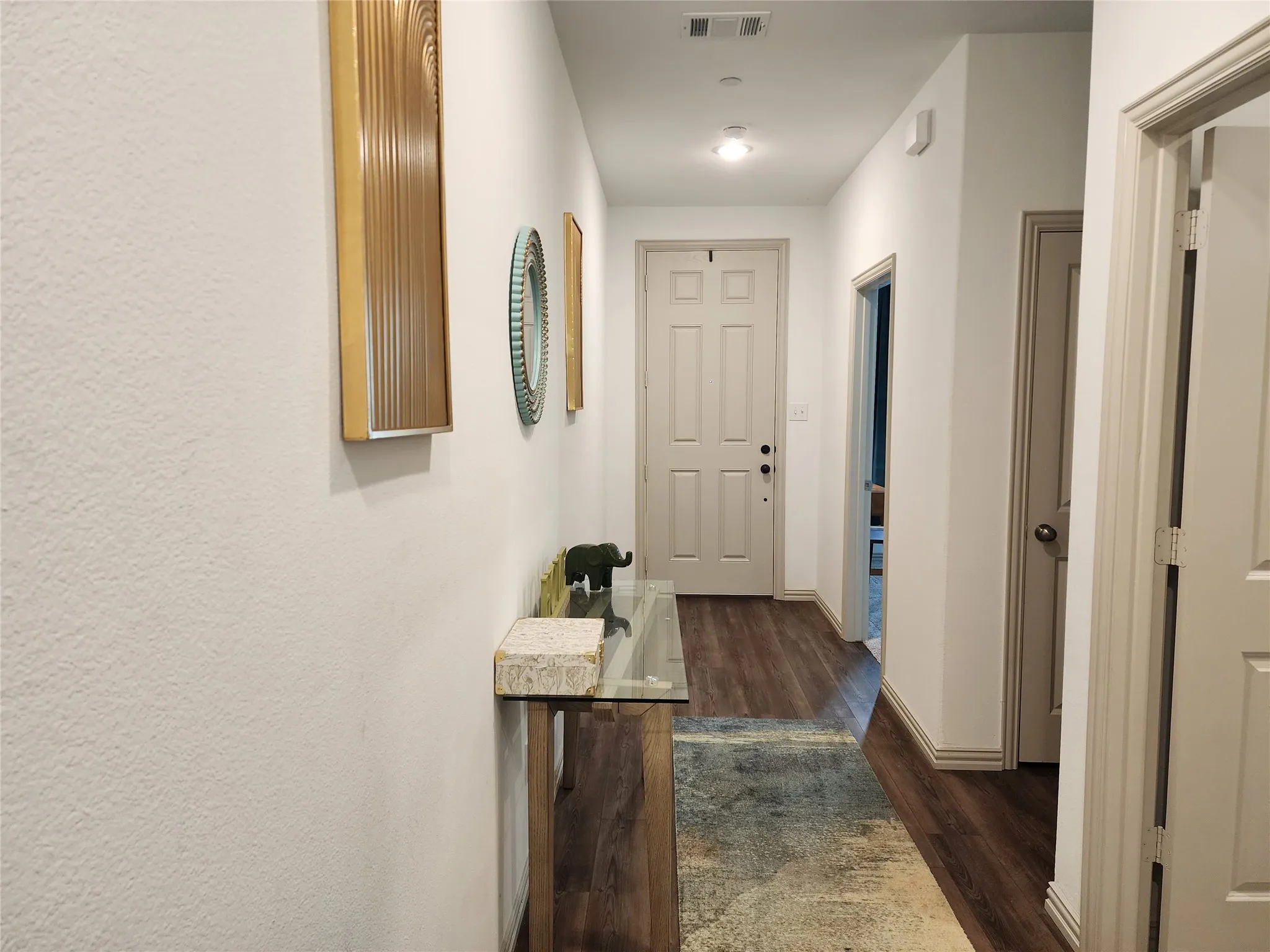 Hall with dark wood-style floors and baseboards