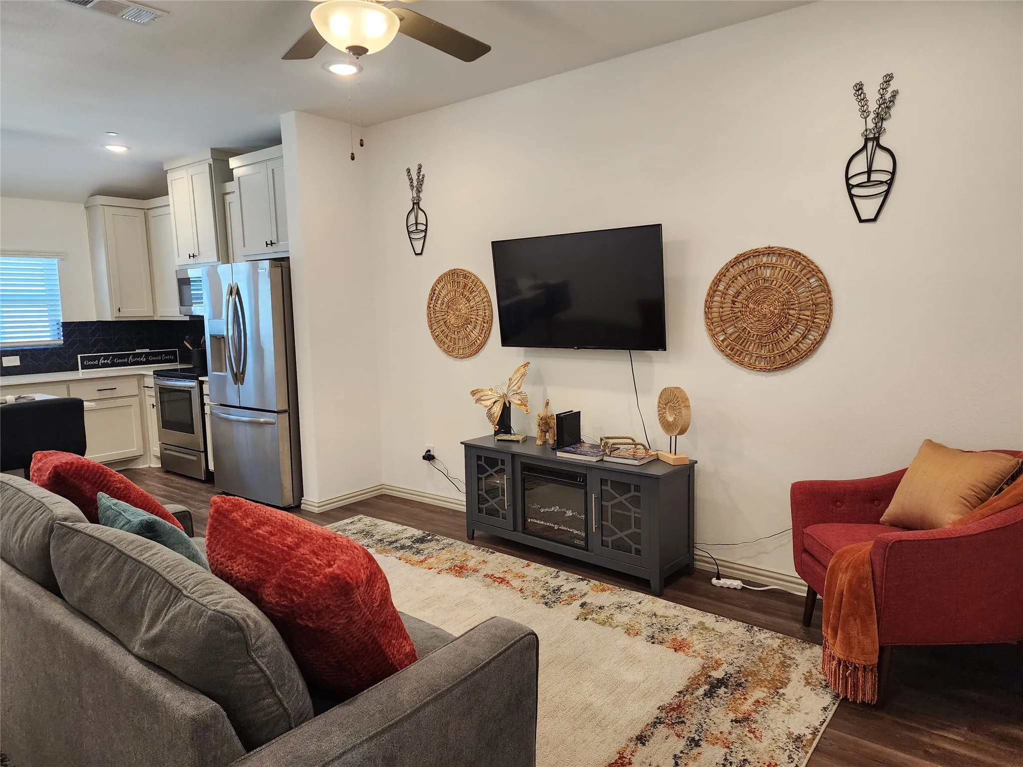 Living area with dark wood finished floors, ceiling fan, and recessed lighting