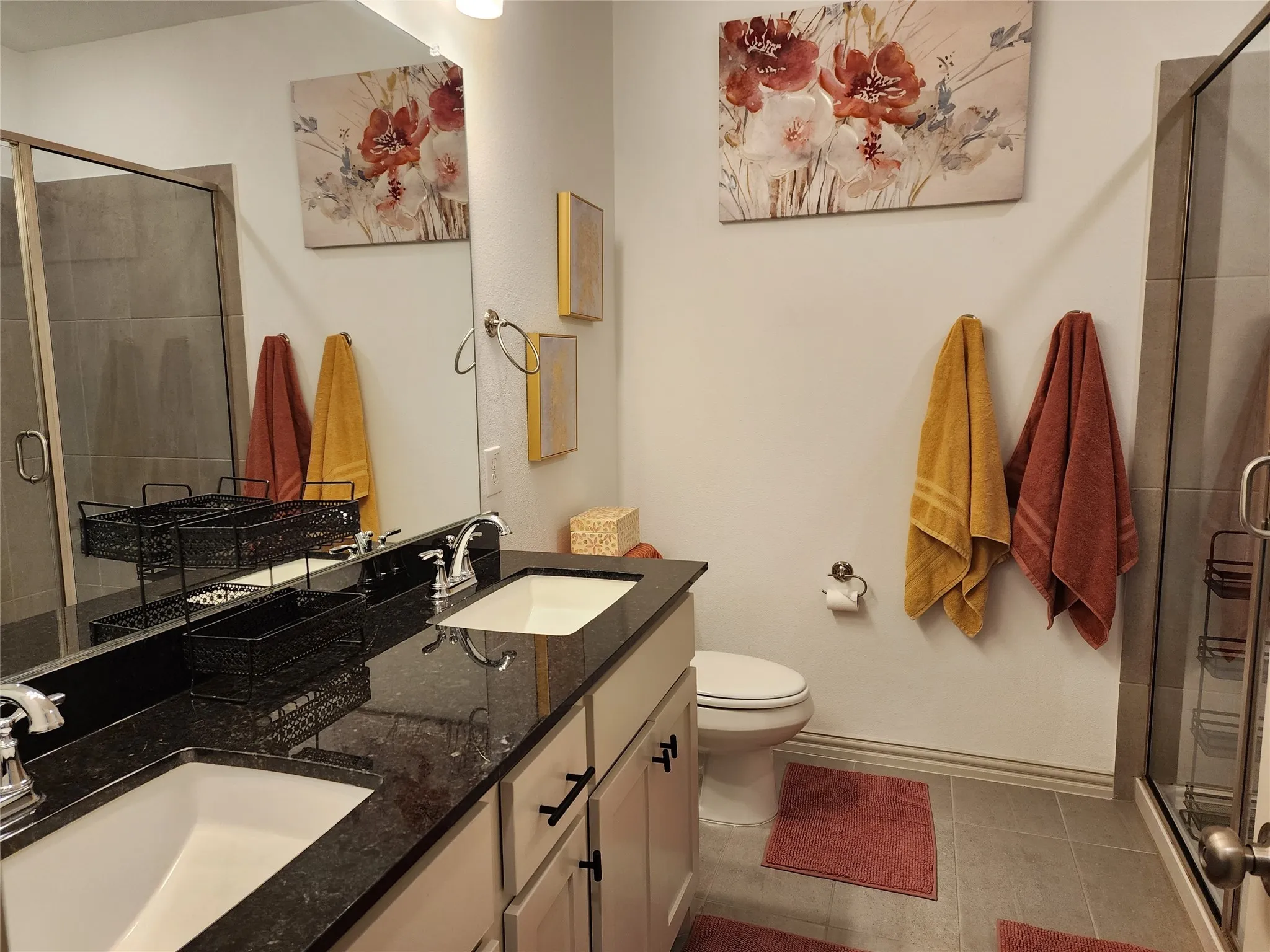 Full bathroom with a stall shower, double vanity, and light tile patterned flooring