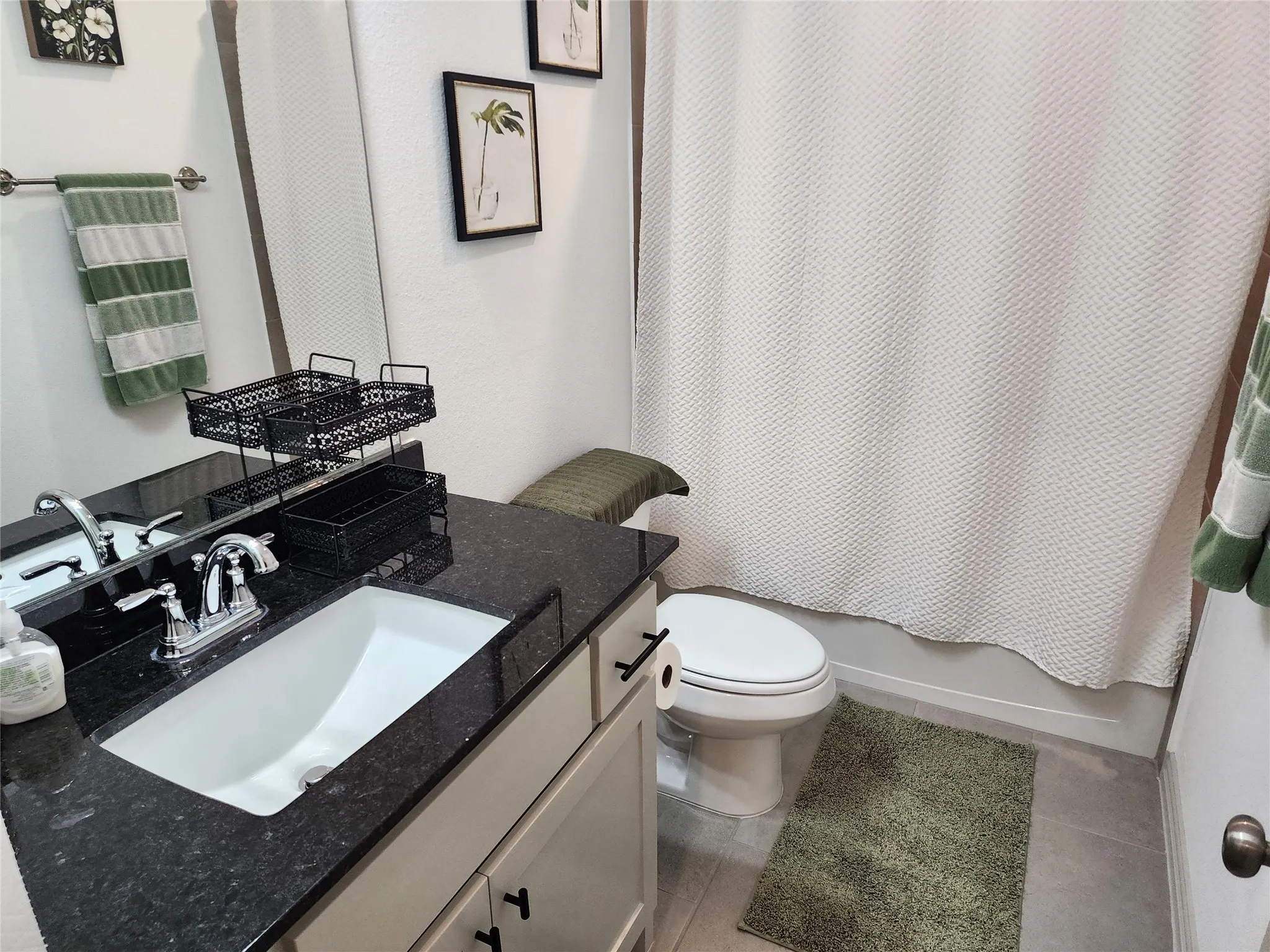 Bathroom with shower / bathtub combination with curtain, vanity, and light tile patterned flooring