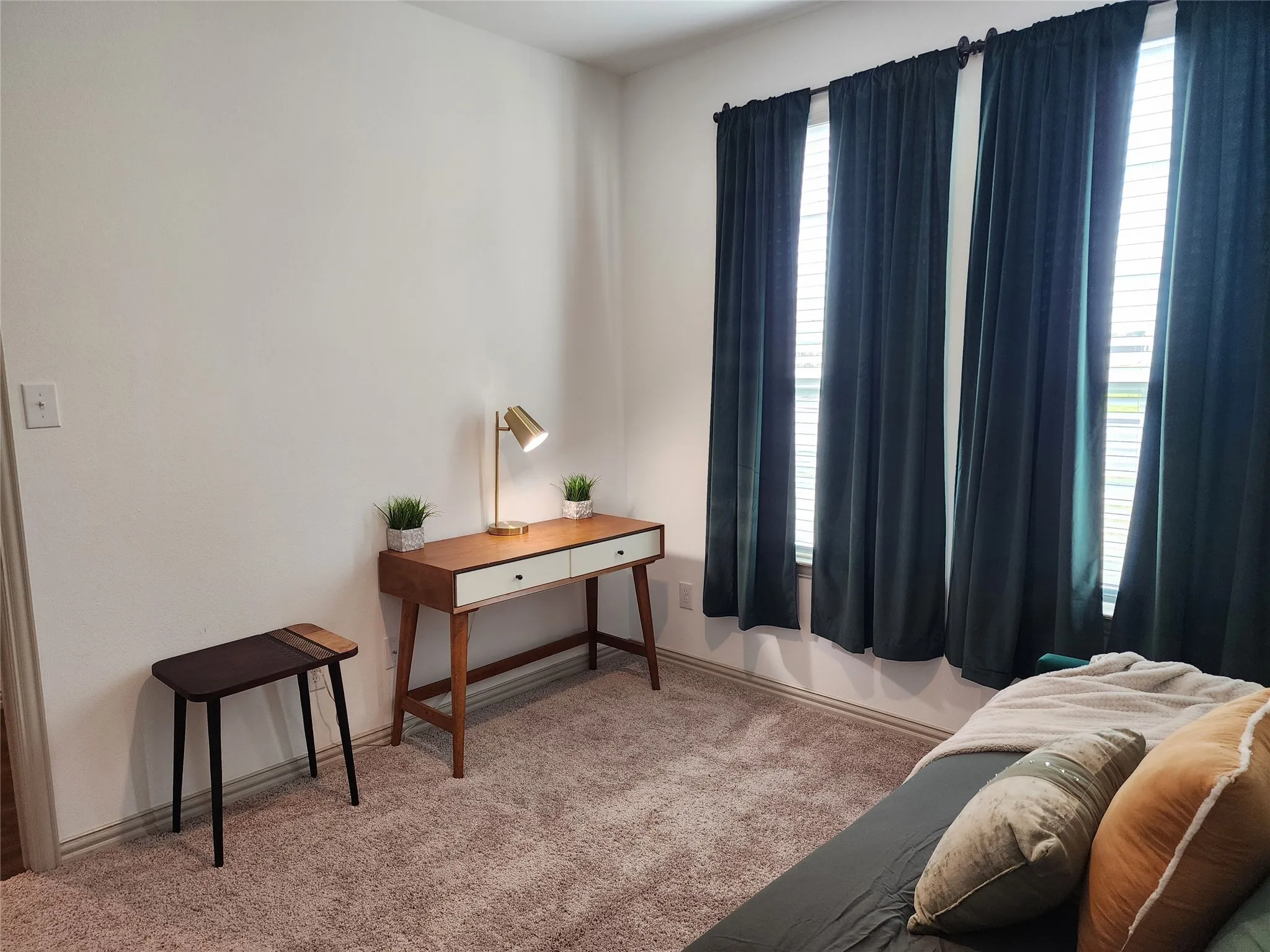 Living area featuring light carpet and baseboards