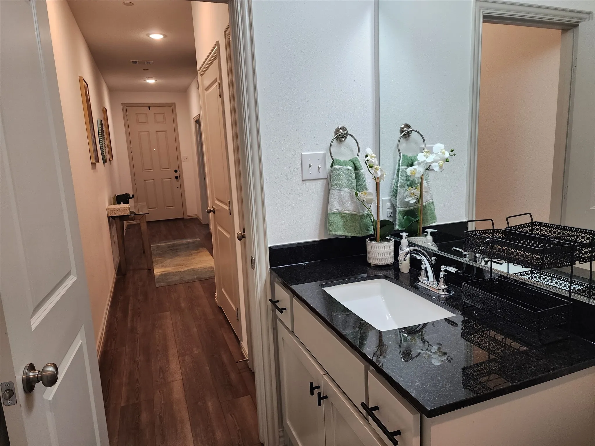 Bathroom featuring dark wood finished floors, vanity, and recessed lighting