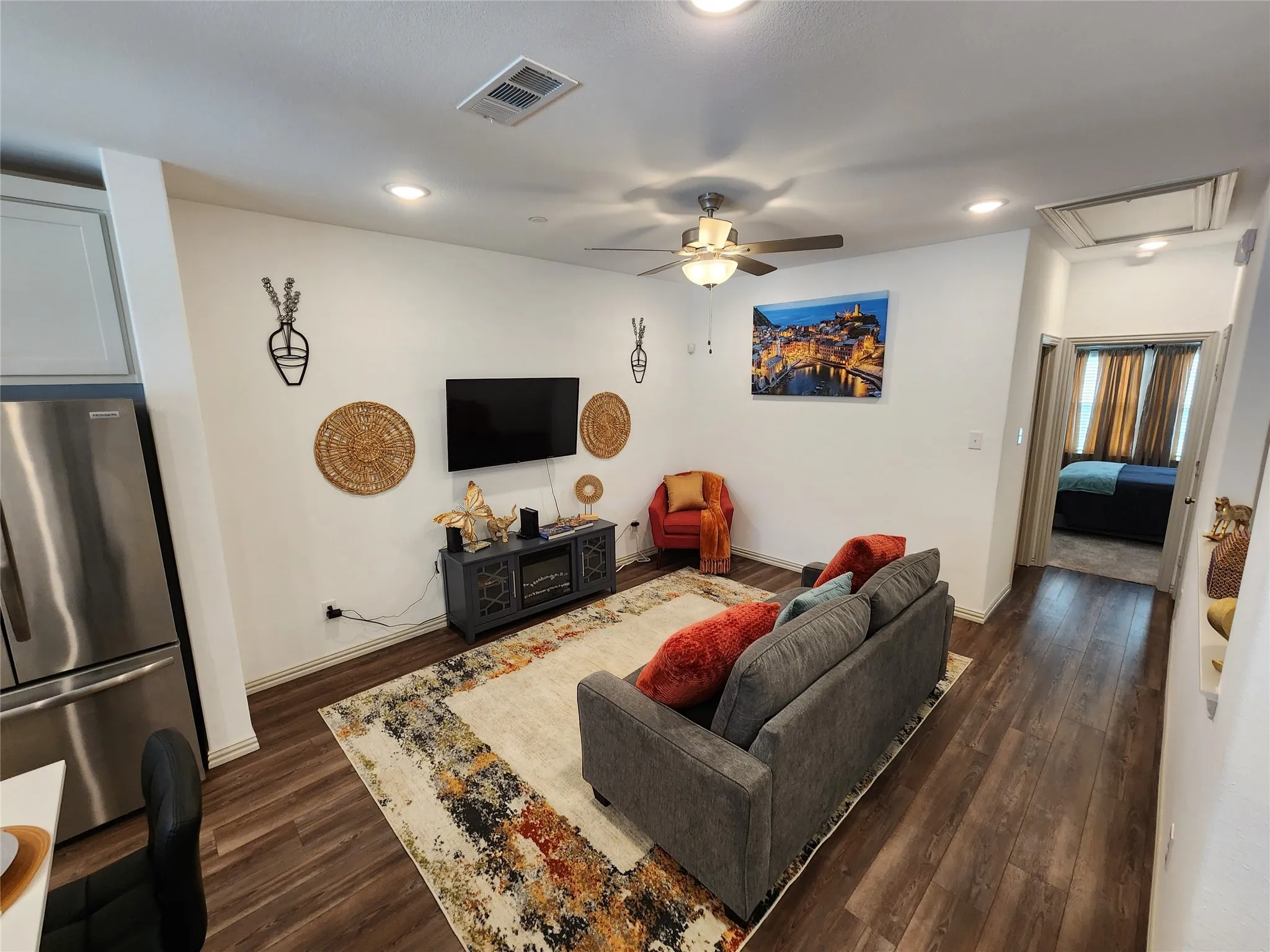 Living room featuring ceiling fan, dark wood-style floors, and recessed lighting