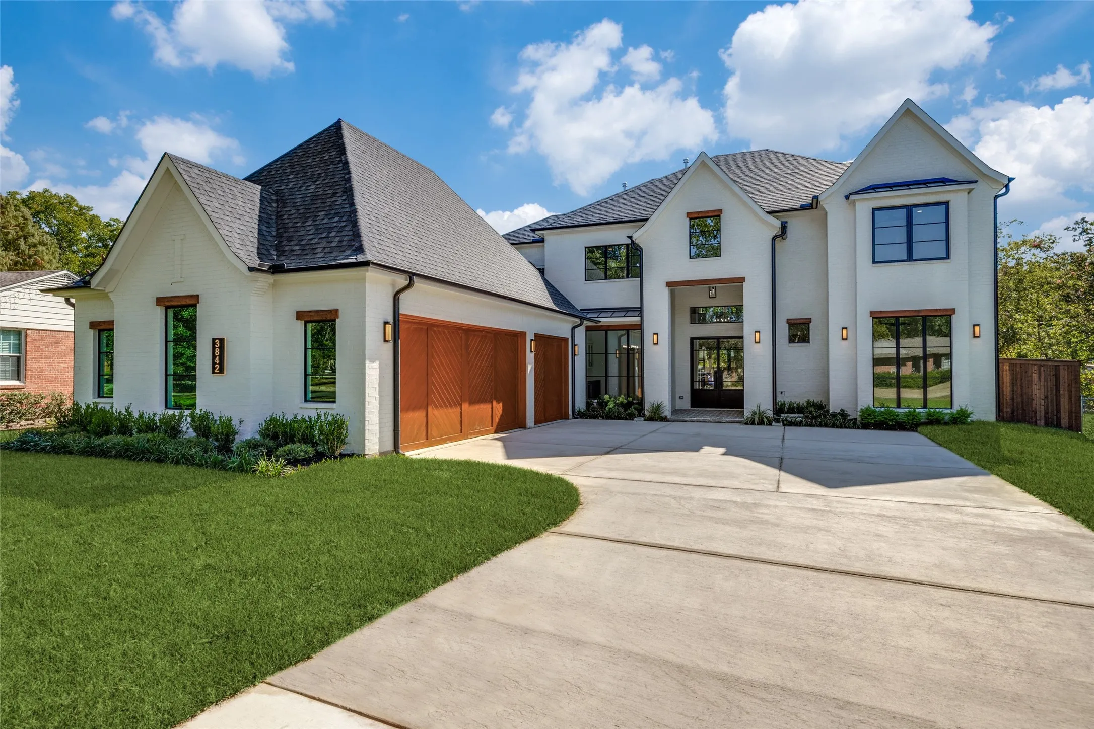 View of front facade with driveway, brick siding, a front yard, a shingled roof, and a garage
