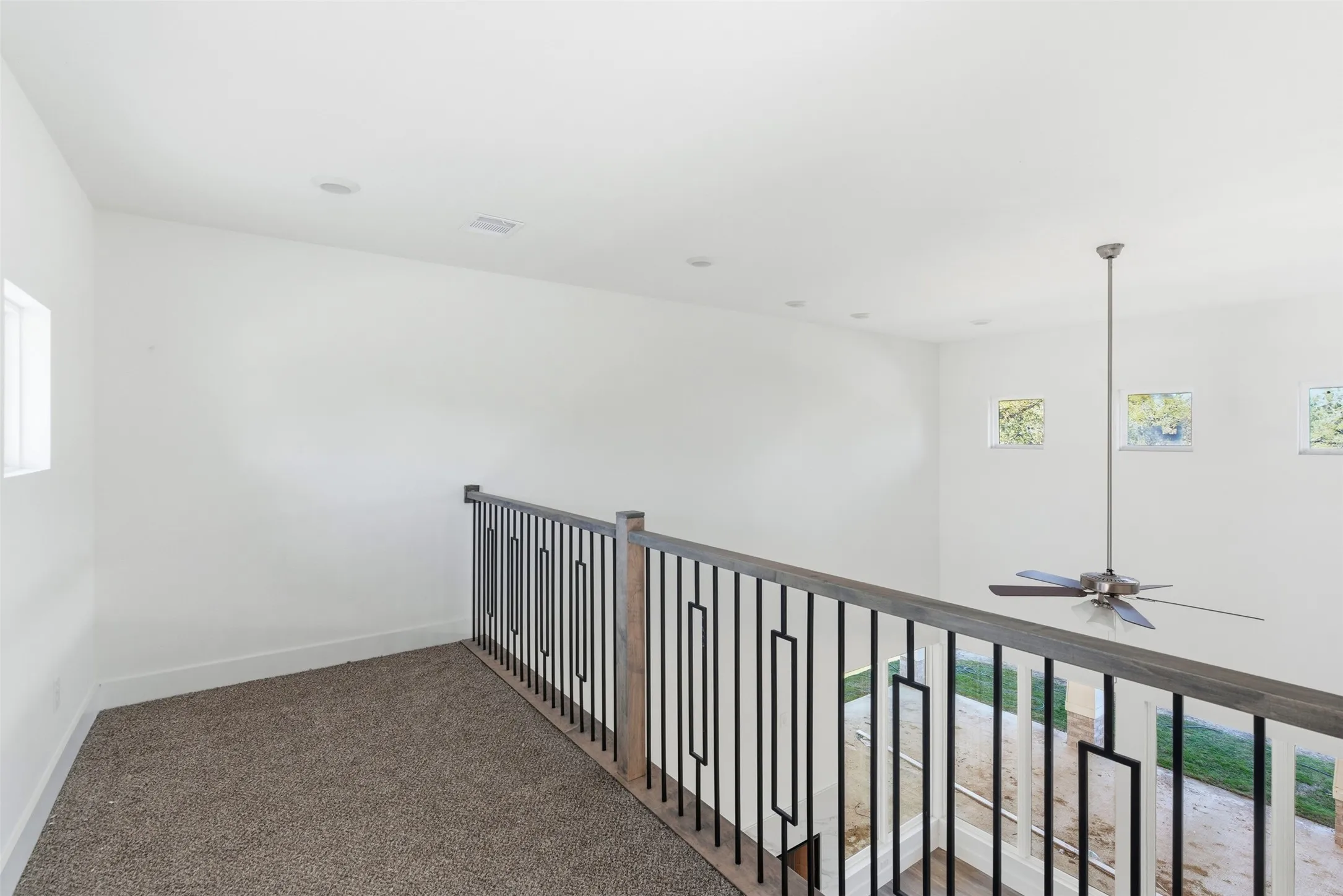 Hallway featuring healthy amount of natural light and carpet floors