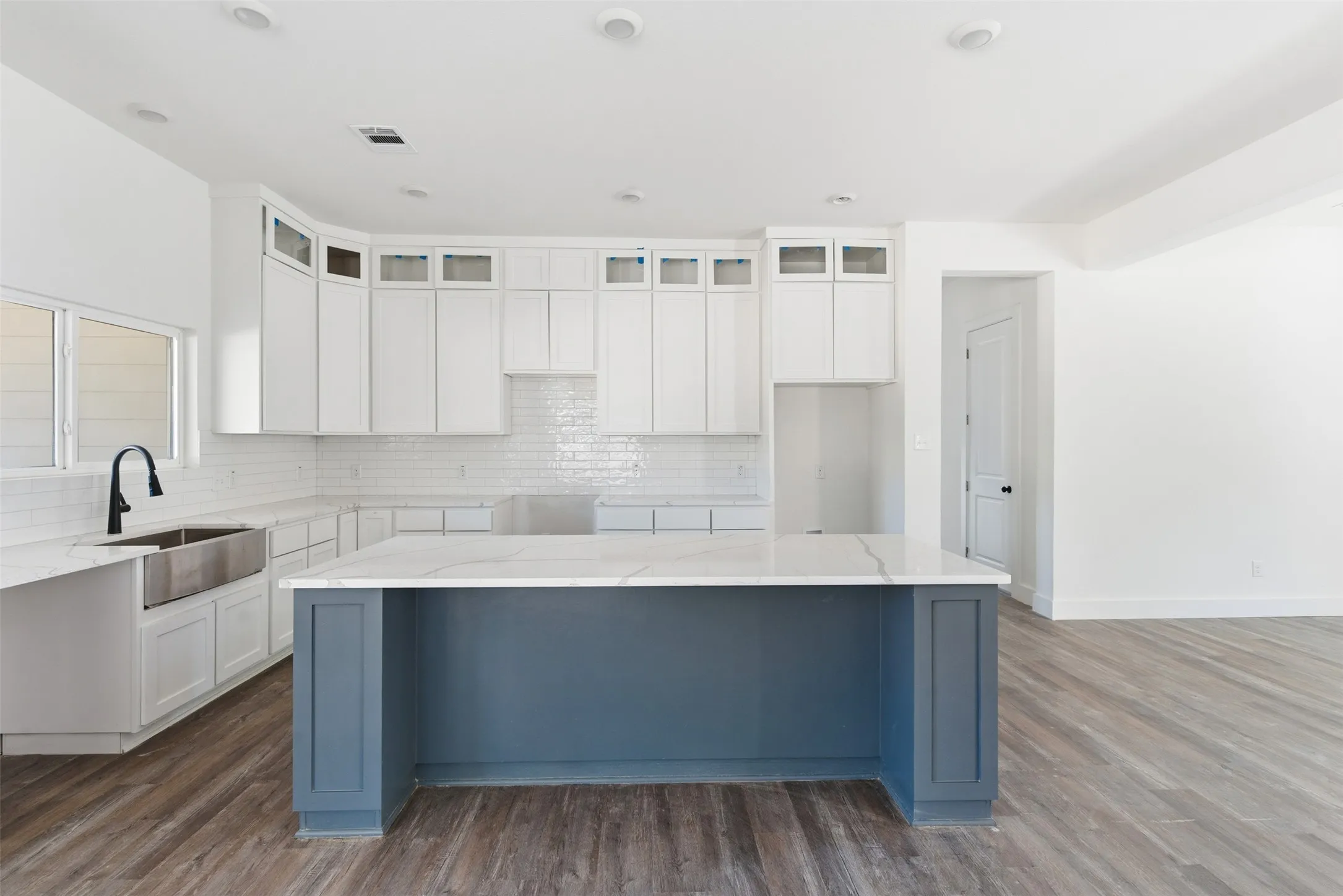 Kitchen featuring white cabinetry, tasteful backsplash, dark wood-style floors, light stone countertops, and recessed lighting