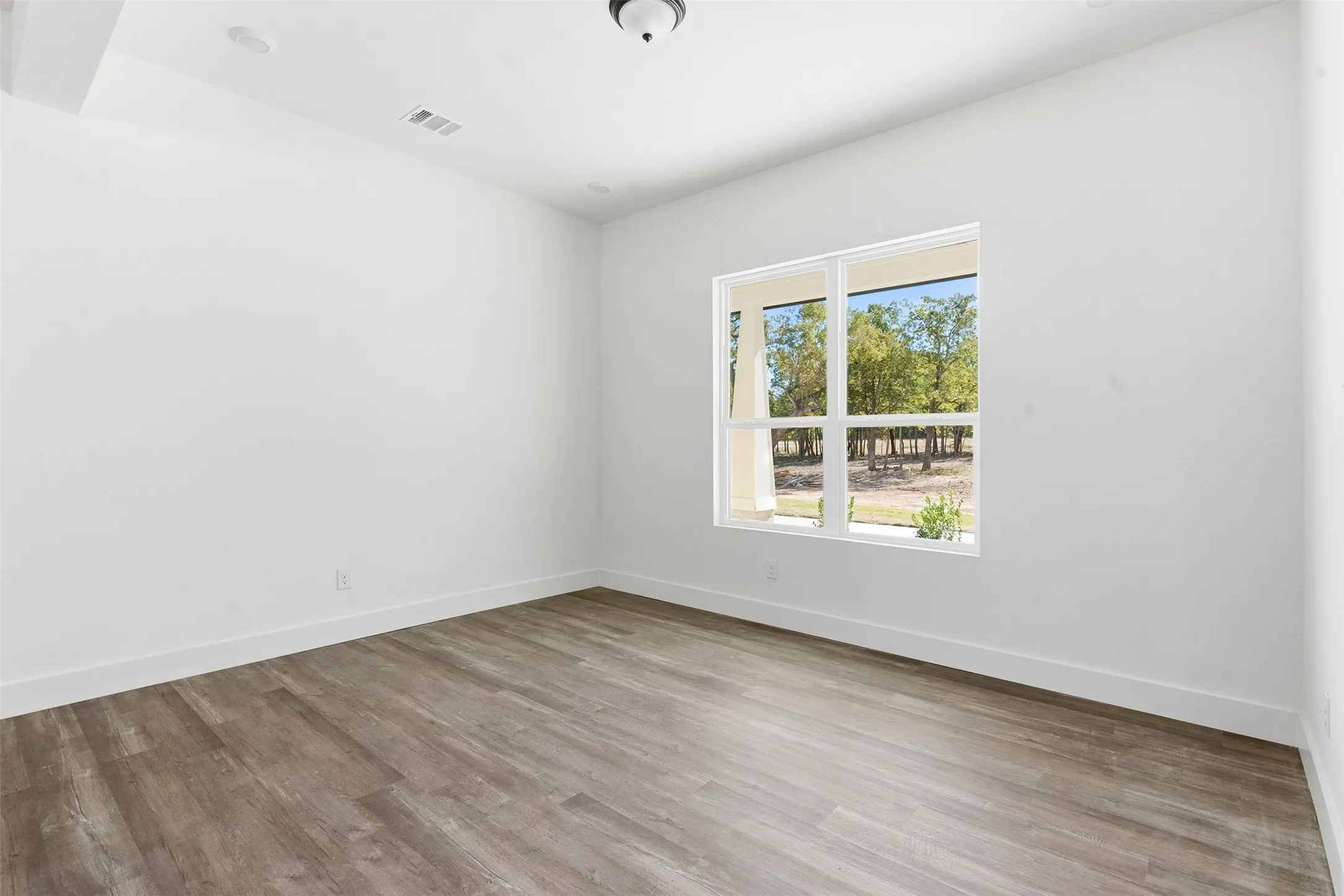 Empty room with light wood-style flooring and baseboards