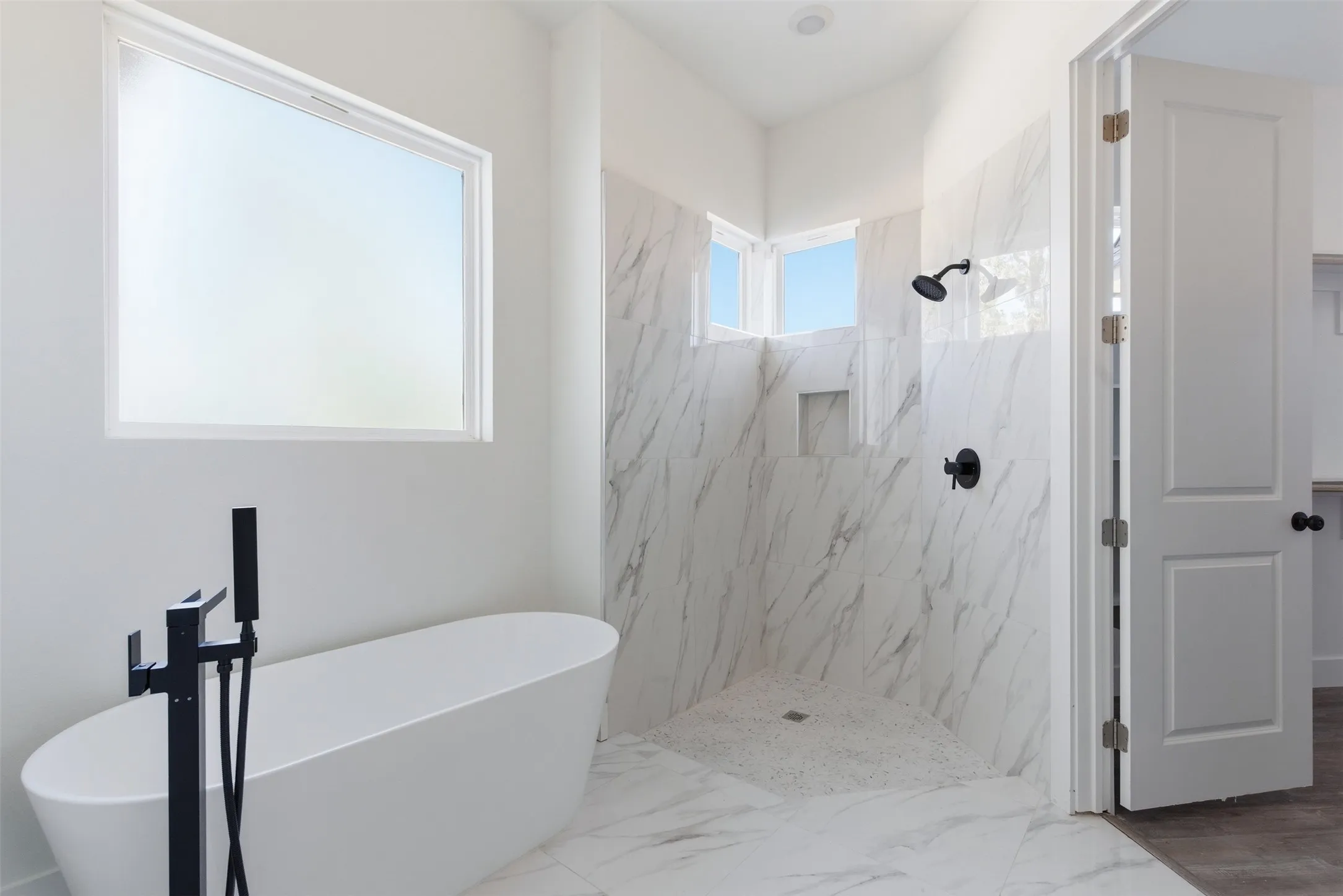 Bathroom featuring a soaking tub, a marble finish shower, and marble finish floors