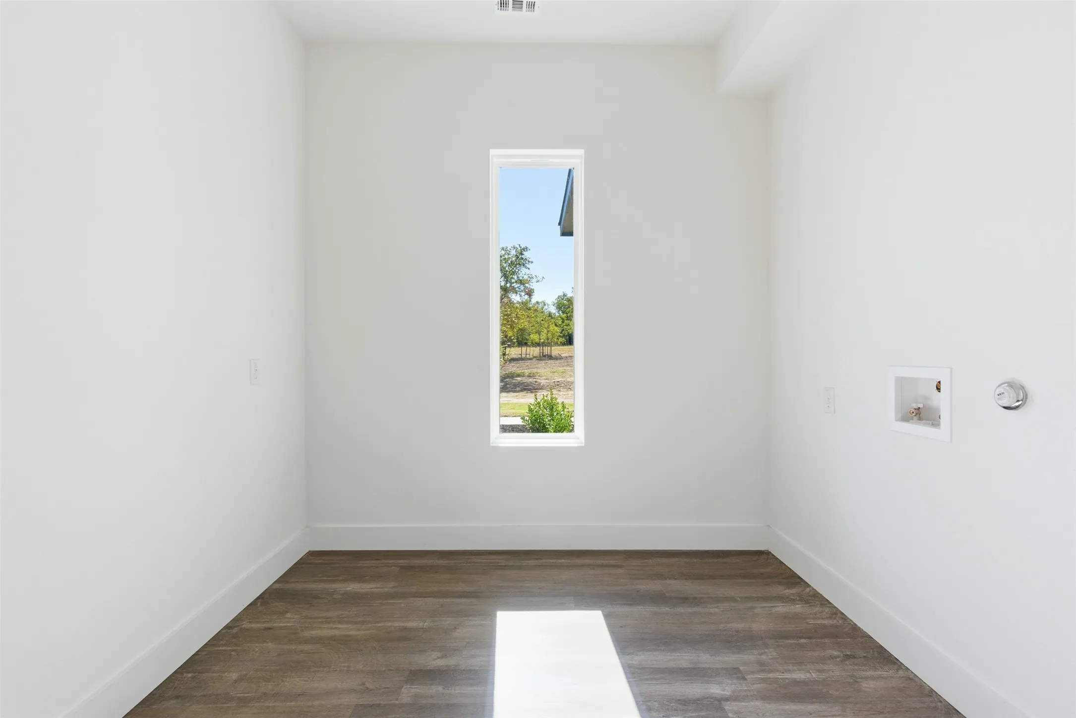 Washroom with dark wood-type flooring and washer hookup